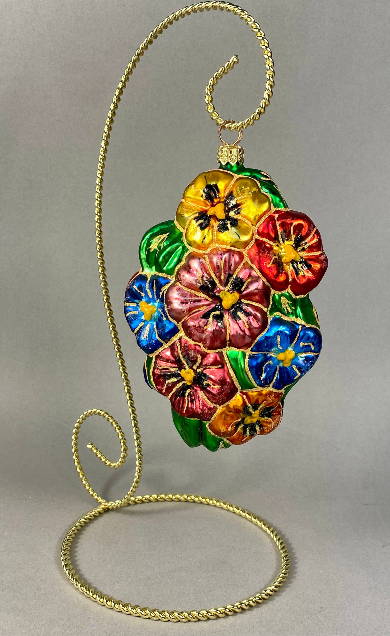 Christopher Radko Hand-Blown Glass Pansy Bouquet Christmas Ornament: A hand-blown glass Christmas ornament designed by Christopher Radko, featuring a vertical cluster of pansy blossoms. The design depicts individual flowers in shades of yellow, deep red, magenta, and r