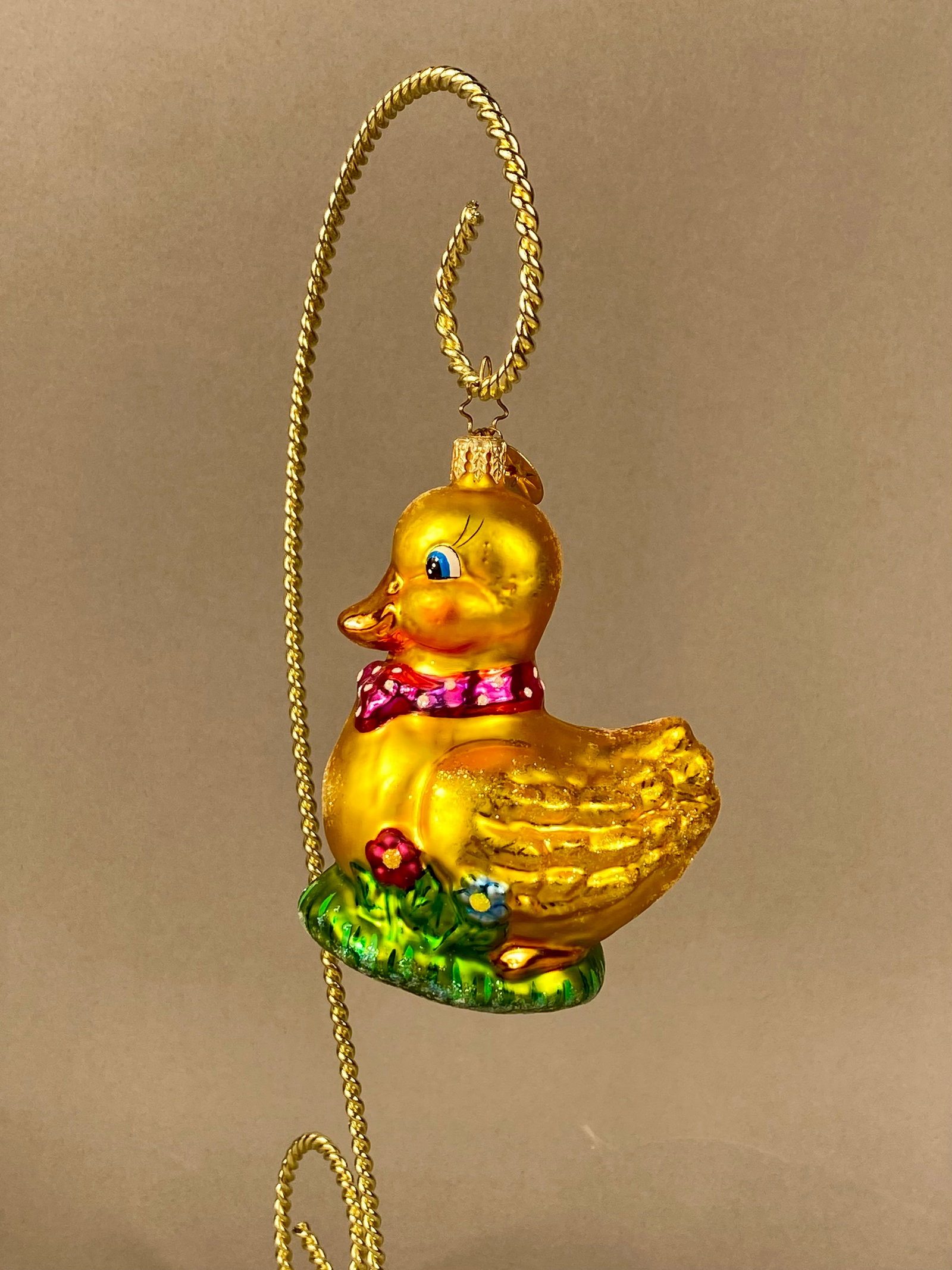 Christopher Radko Duck Delight Blown Glass Figural Ornament: This is a mouth-blown, hand-painted glass figural ornament by Christopher Radko, identified as the Duck Delight pattern. The ornament depicts a yellow duckling wearing a pink scarf with white polka do