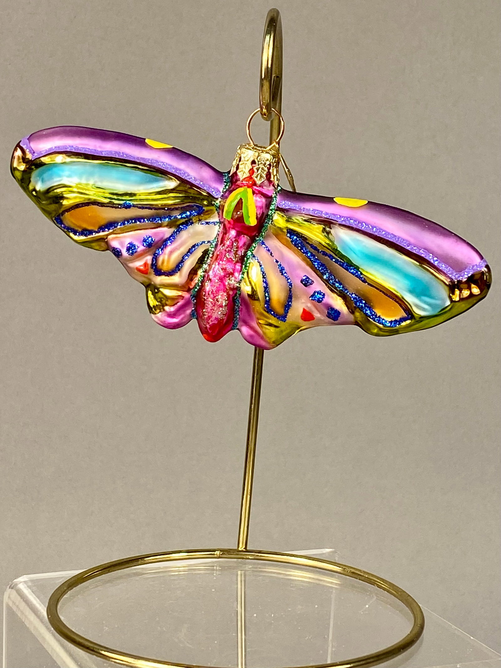 Christopher Radko Attributed Mouth Blown Glass Butterfly Ornament: A mouth blown glass Christmas ornament in the form of a butterfly, attributed to Christopher Radko. The piece is crafted from hand blown glass and features a multi color palette. The upper wings are f