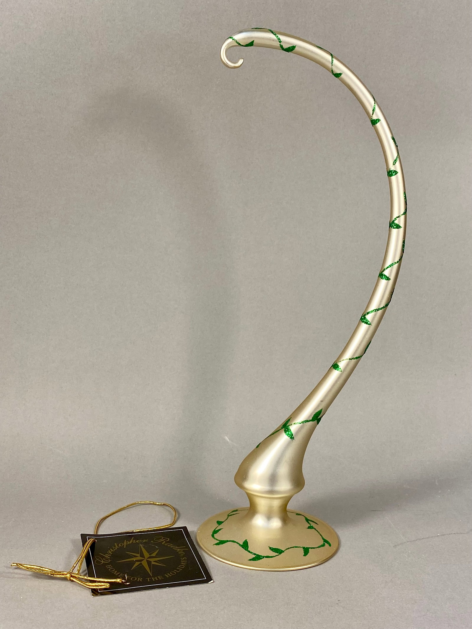 Christopher Radko Home for the Holidays Glass Ivy Ornament Holder: Christopher Radko Glass Ivy Ornament Holder from the Home for the Holidays collection. This single-prong display stand is constructed of blown glass with a champagne-gold satin finish. The design feat