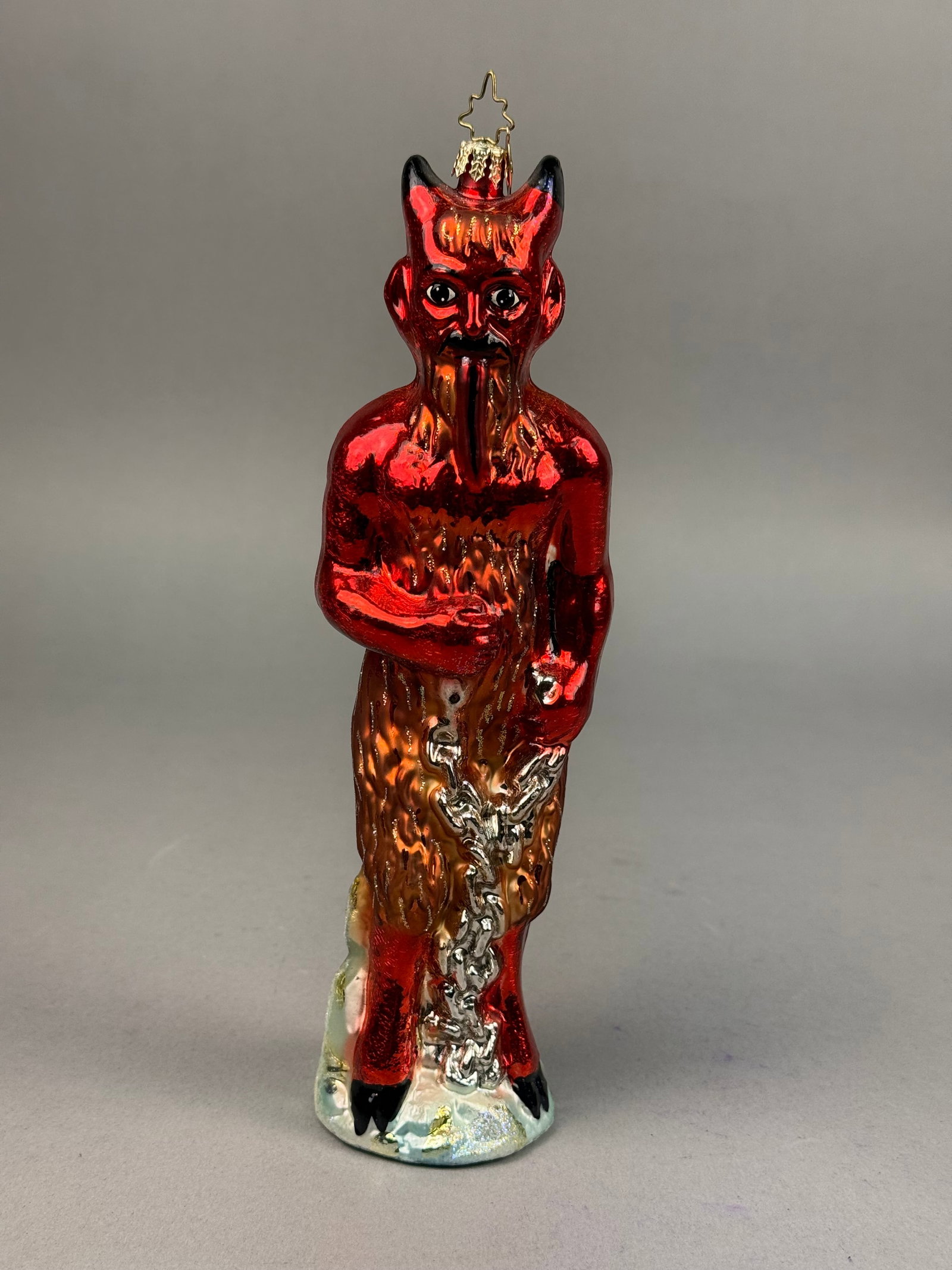 Radko Krampus Hand Blown Glass Ornament: This hand-blown glass Christmas ornament is produced by Christopher Radko and depicts the folkloric figure Krampus. The piece includes a gold-tone metal cap and a signature star-shaped wire hanging lo