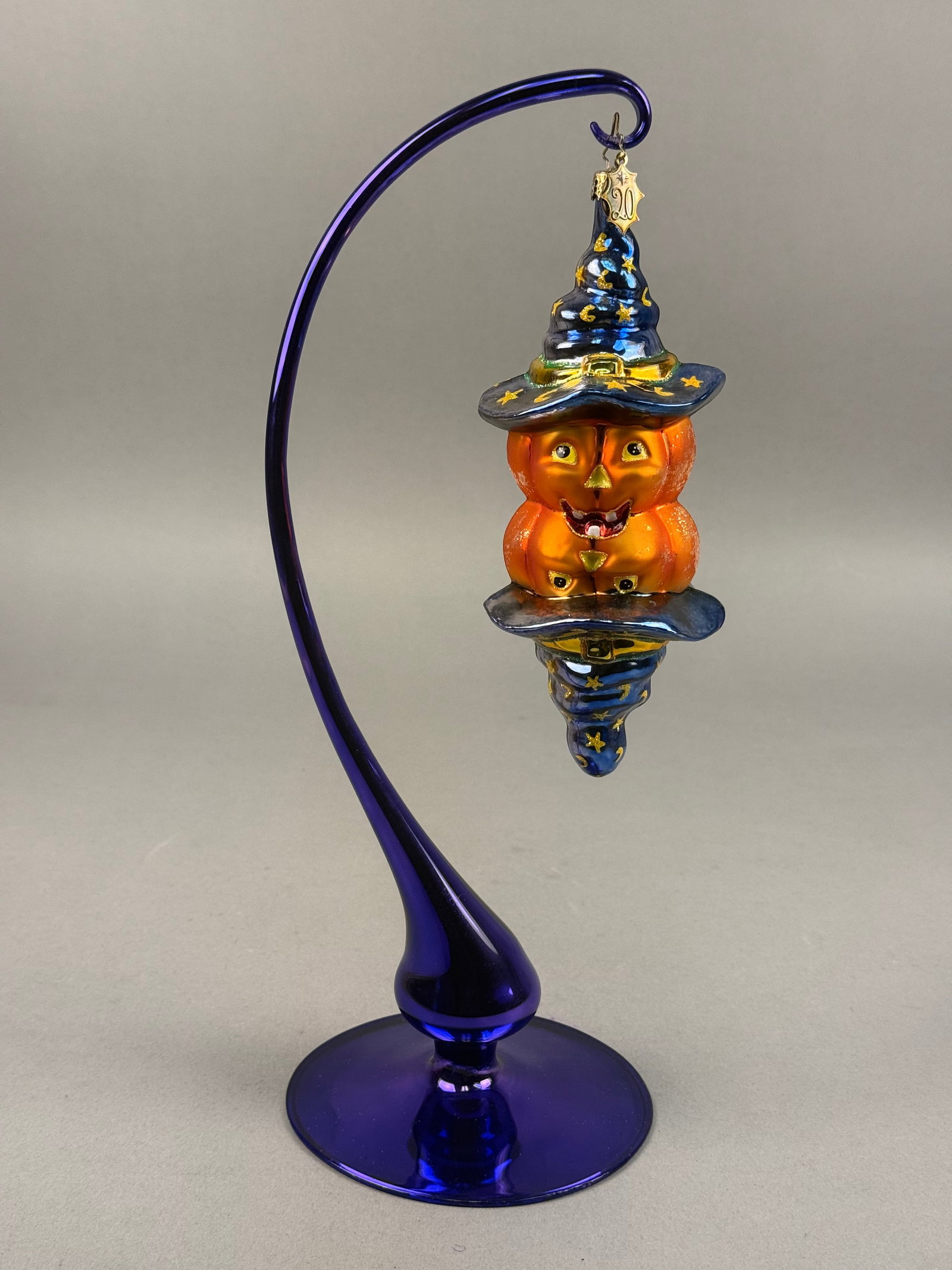 Radko Double-Ended Pumpkin Blown Glass Halloween Ornament: Ornament stand NOT INCLUDED. This hand-blown glass holiday ornament features a whimsical double-ended design depicting two conjoined pumpkin-headed wizard figures. One end of the ornament is fitted wi