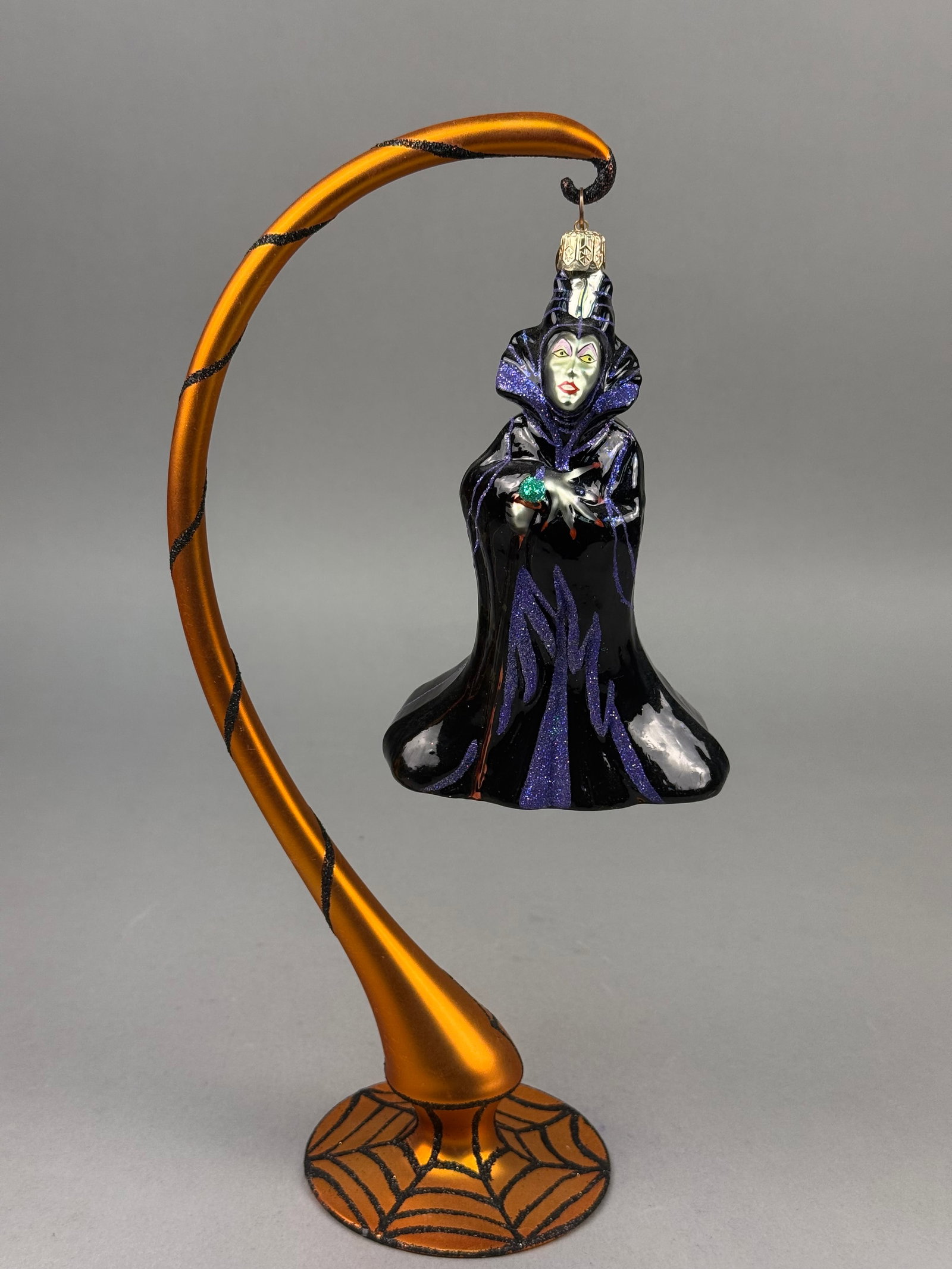 Radko Disney Sleeping Beauty Maleficent Blown Glass Ornament: A Disney Sleeping Beauty Maleficent blown glass Christmas ornament by Christopher Radko. This collectible figure depicts the villain Maleficent in long, flowing black and purple robes with purple glit
