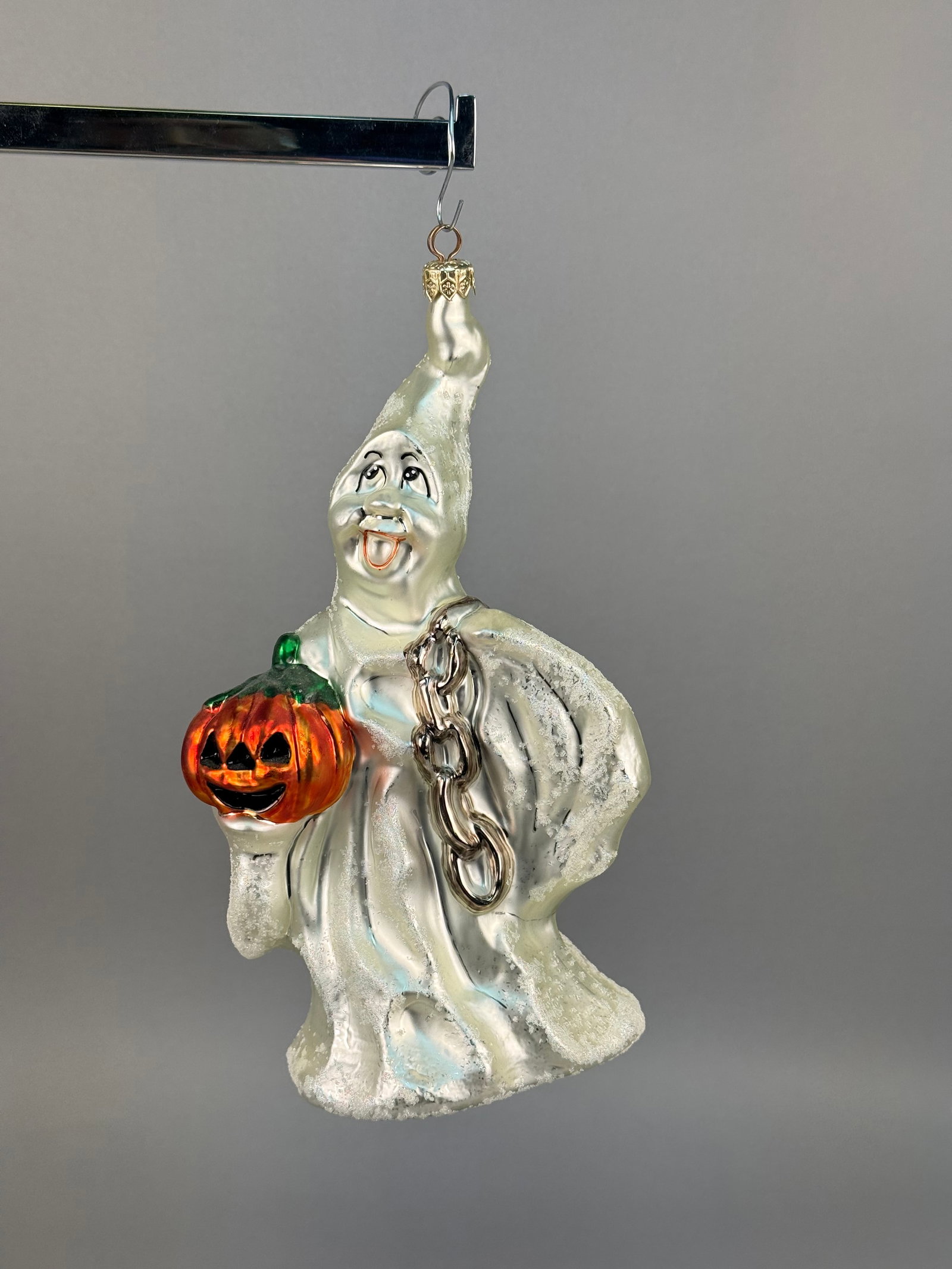 Radko Shake Rattle and Roll Halloween Ghost Glass Ornament: This hand-blown glass figural ornament is a Christopher Radko design titled Shake Rattle and Roll. The ornament features a whimsical, friendly ghost with a hand-painted smiling face, black eyes, and a