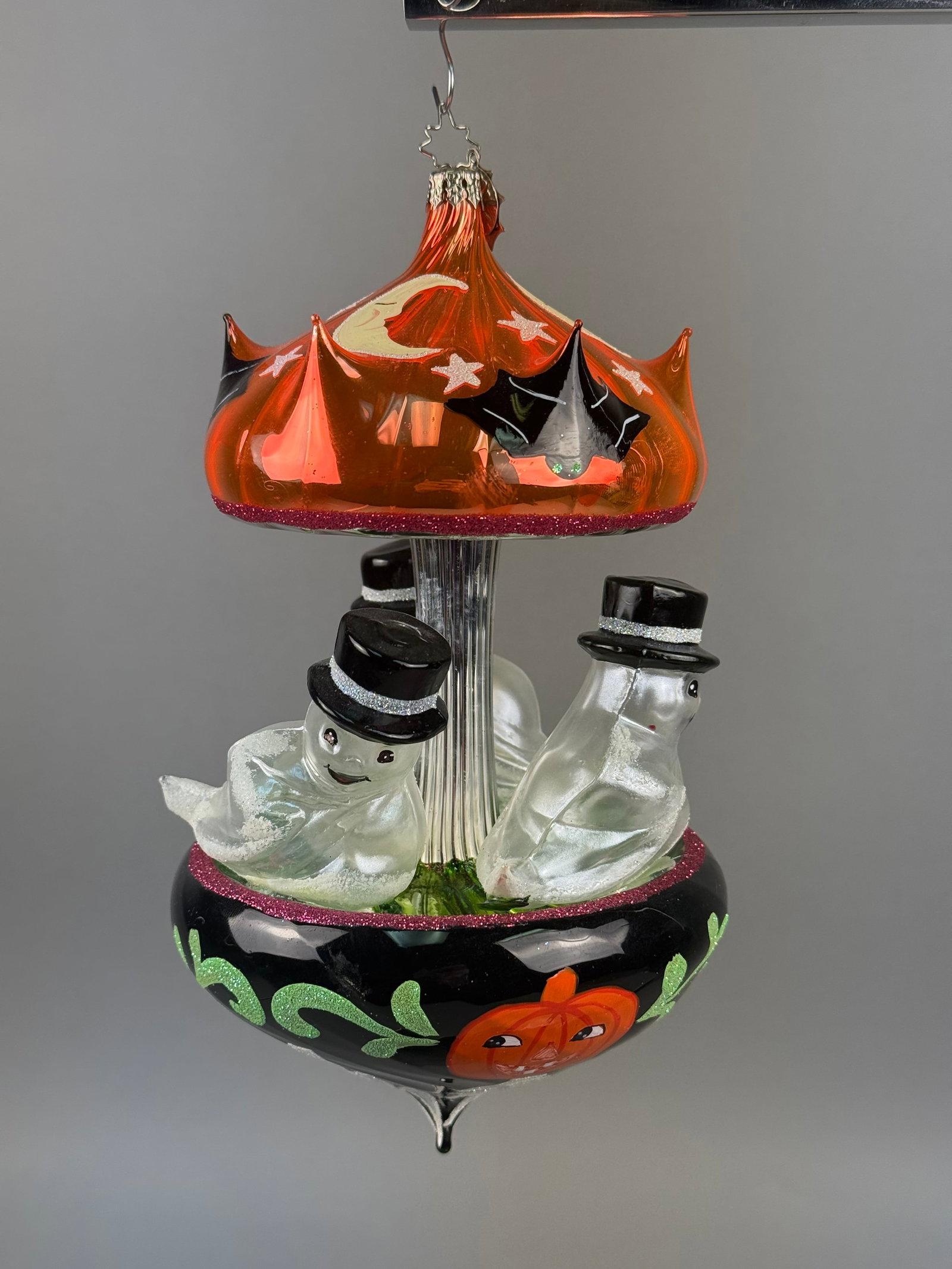 Radko 20th Anniversary Halloween Carousel Glass Ornament: This is a large, mouth-blown glass Halloween ornament produced by Christopher Radko as a 20th-anniversary commemorative piece. The ornament is topped with a signature silver-toned metal star-shaped ha
