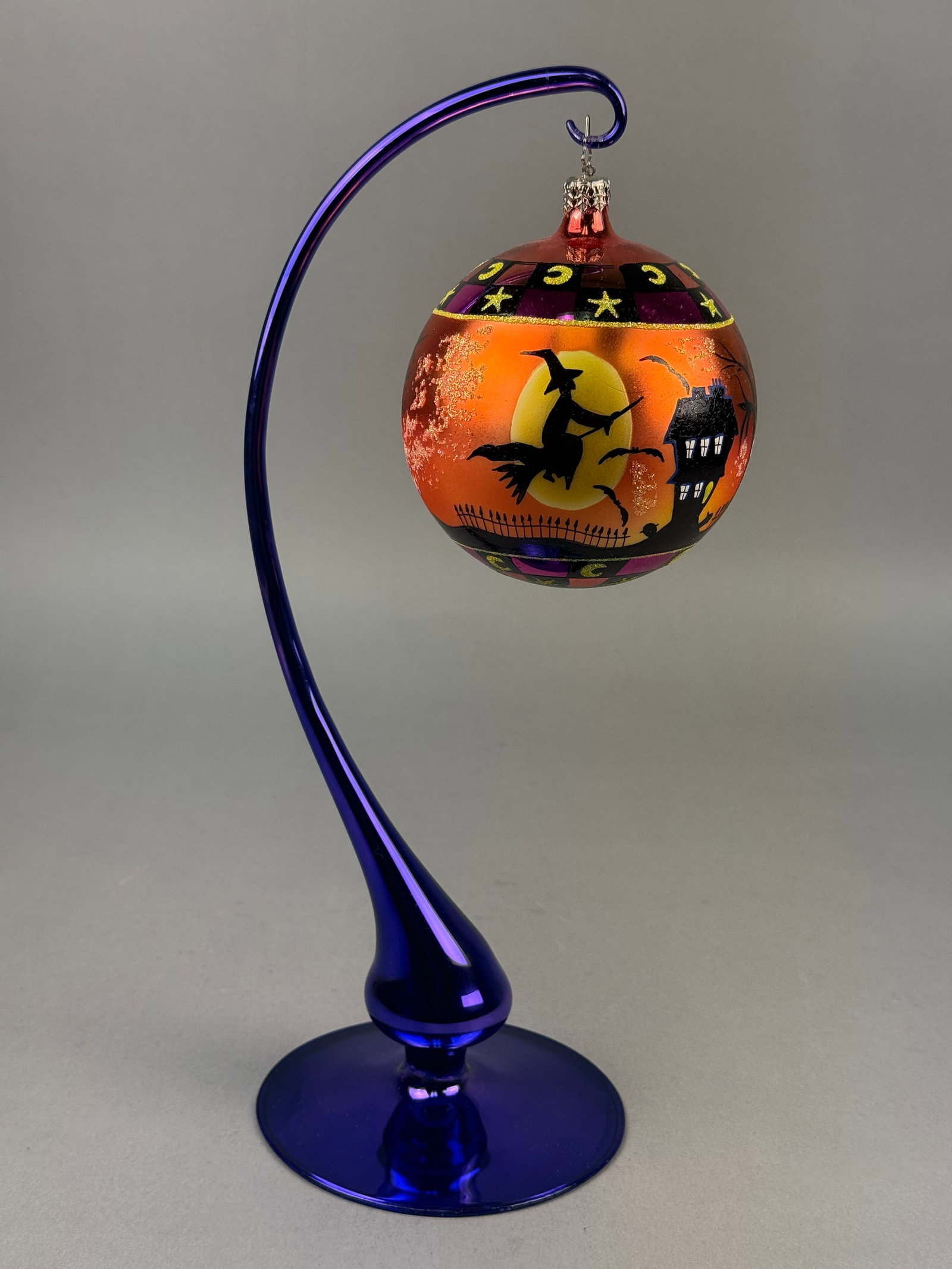 Radko Blown Glass Halloween Haunted House Ball Ornament: A Christopher Radko hand-blown glass ball ornament featuring a festive Halloween theme. The spherical body displays an iridescent metallic orange and gold finish. The ornament is fitted with a silver-