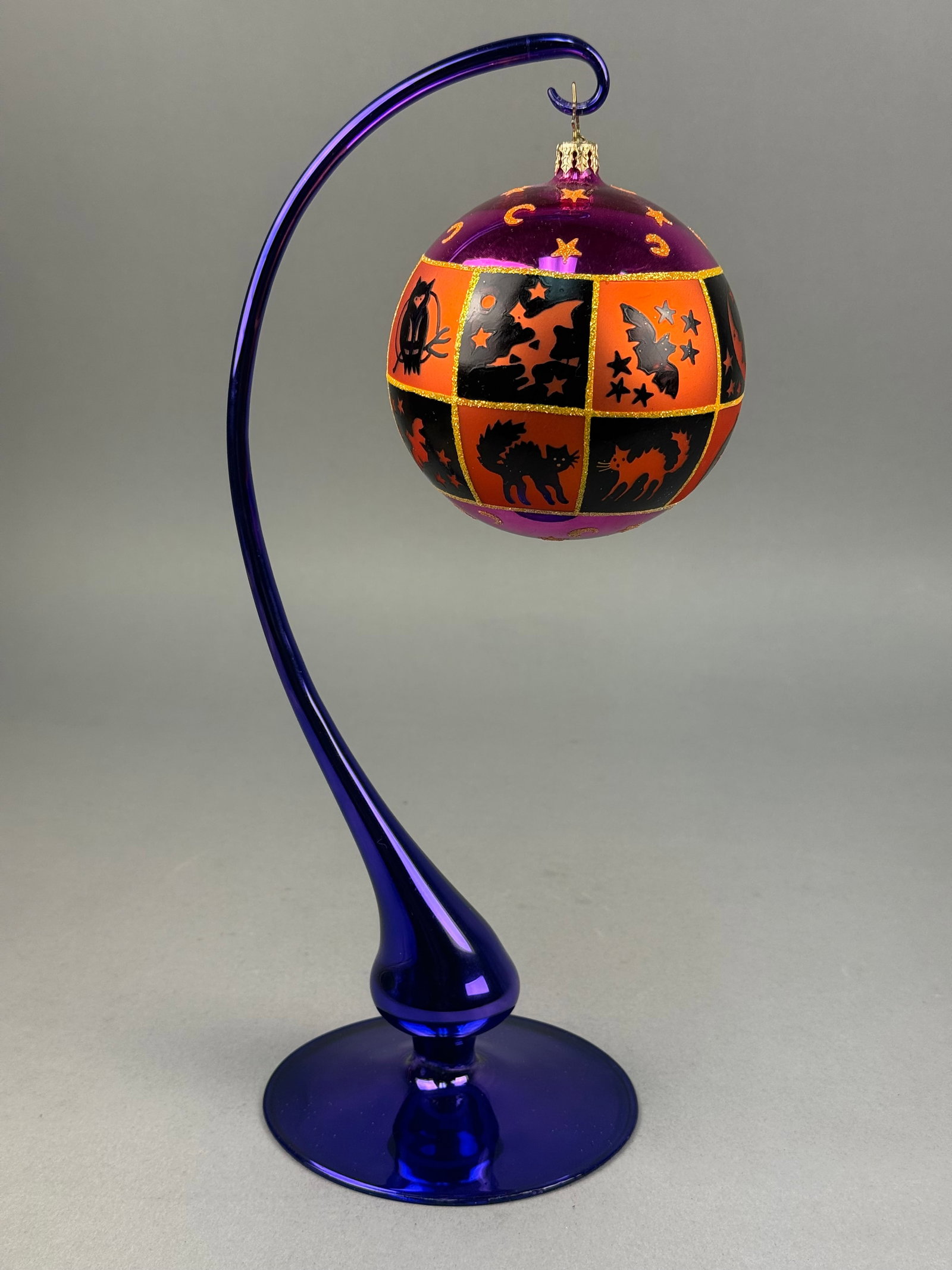 Radko Blown Glass Halloween Checkerboard Ball Ornament: A hand-blown glass spherical ornament by Christopher Radko featuring a multi-colored Halloween-themed design. The ornament is fitted with a gold-tone metal cap embossed with the manufacturer name Chri