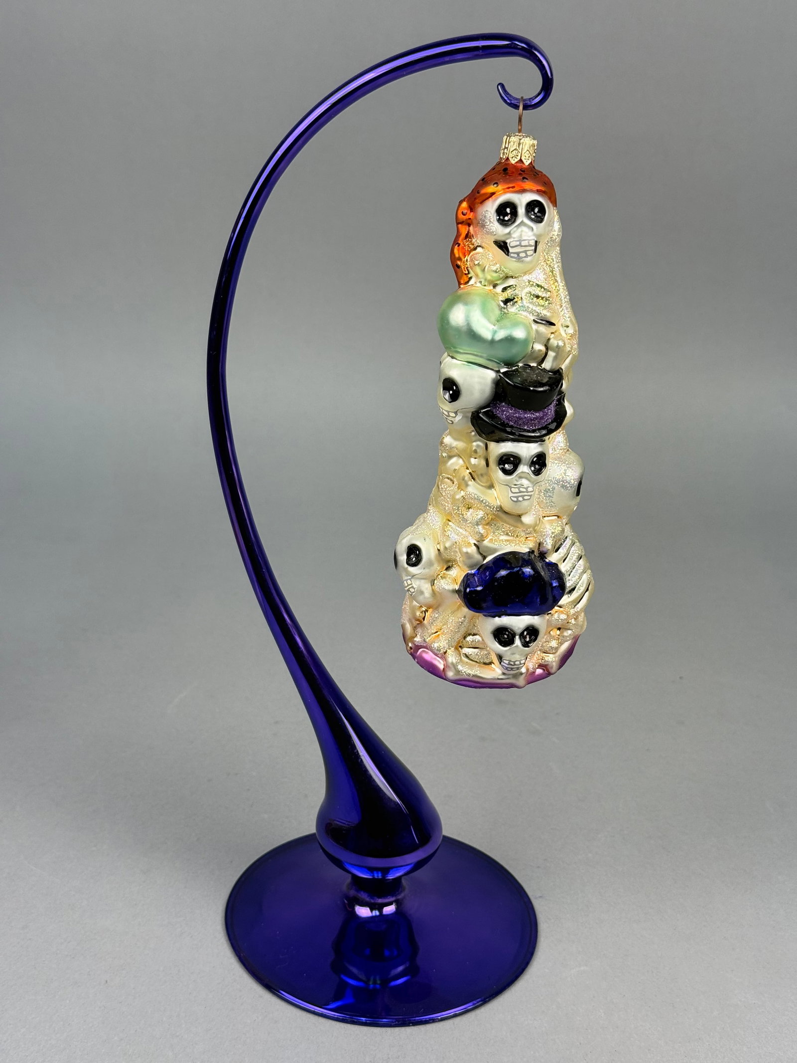 Radko Gathering of Enlightened Souls Day of the Dead Glass Ornament: This is a hand-blown glass holiday ornament by Christopher Radko, from the Day of the Dead (Día de los Muertos) collection, titled Gathering of Enlightened Souls. A gold-toned metal hanging cap