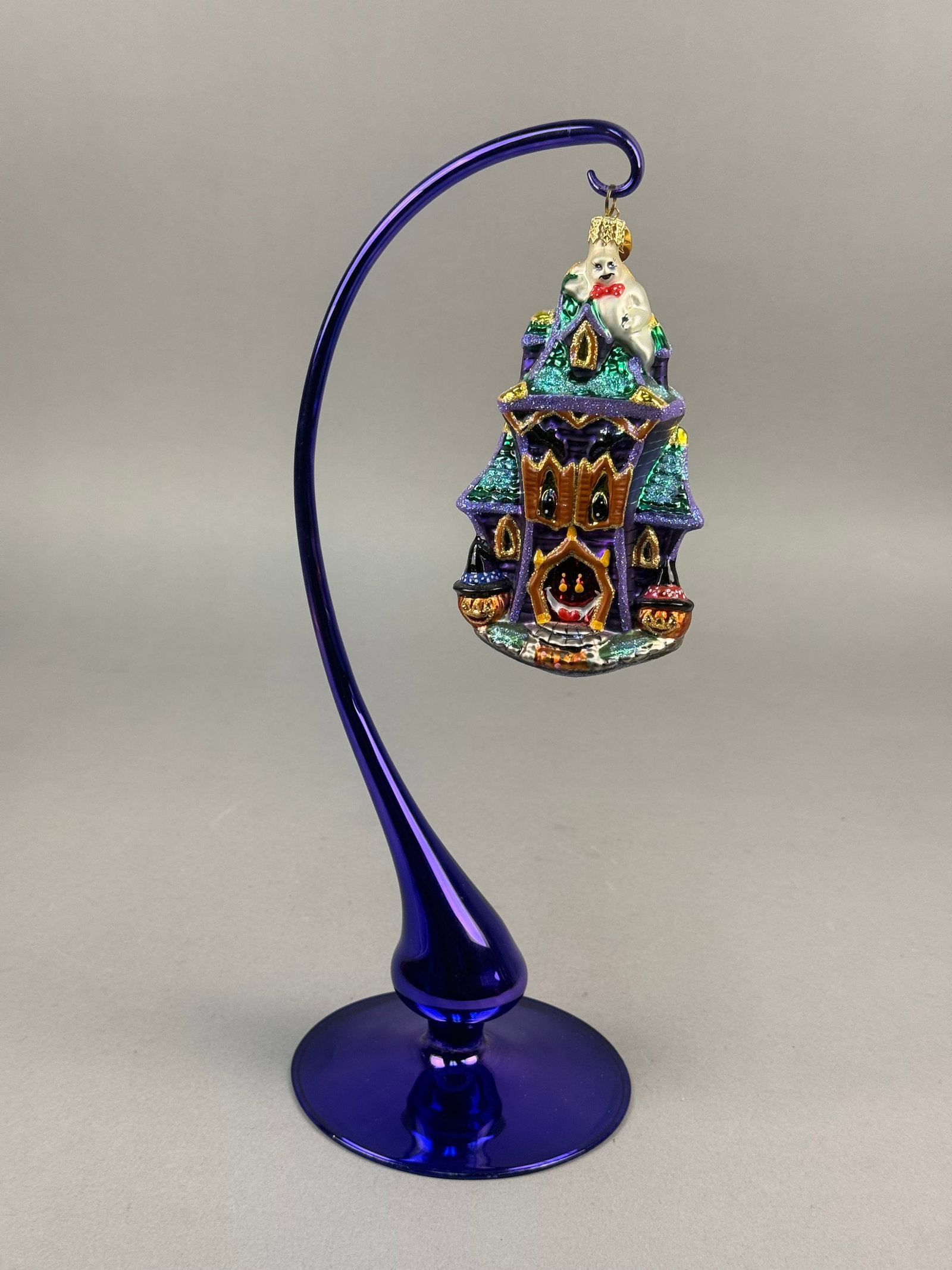 Christopher Radko Haunted House Glass Ornament with Cobalt Glass Stand: This mouth-blown glass holiday ornament by Christopher Radko is designed as a whimsical, multi-storied haunted house. The architectural form is finished in deep purple with vibrant emerald green glitt
