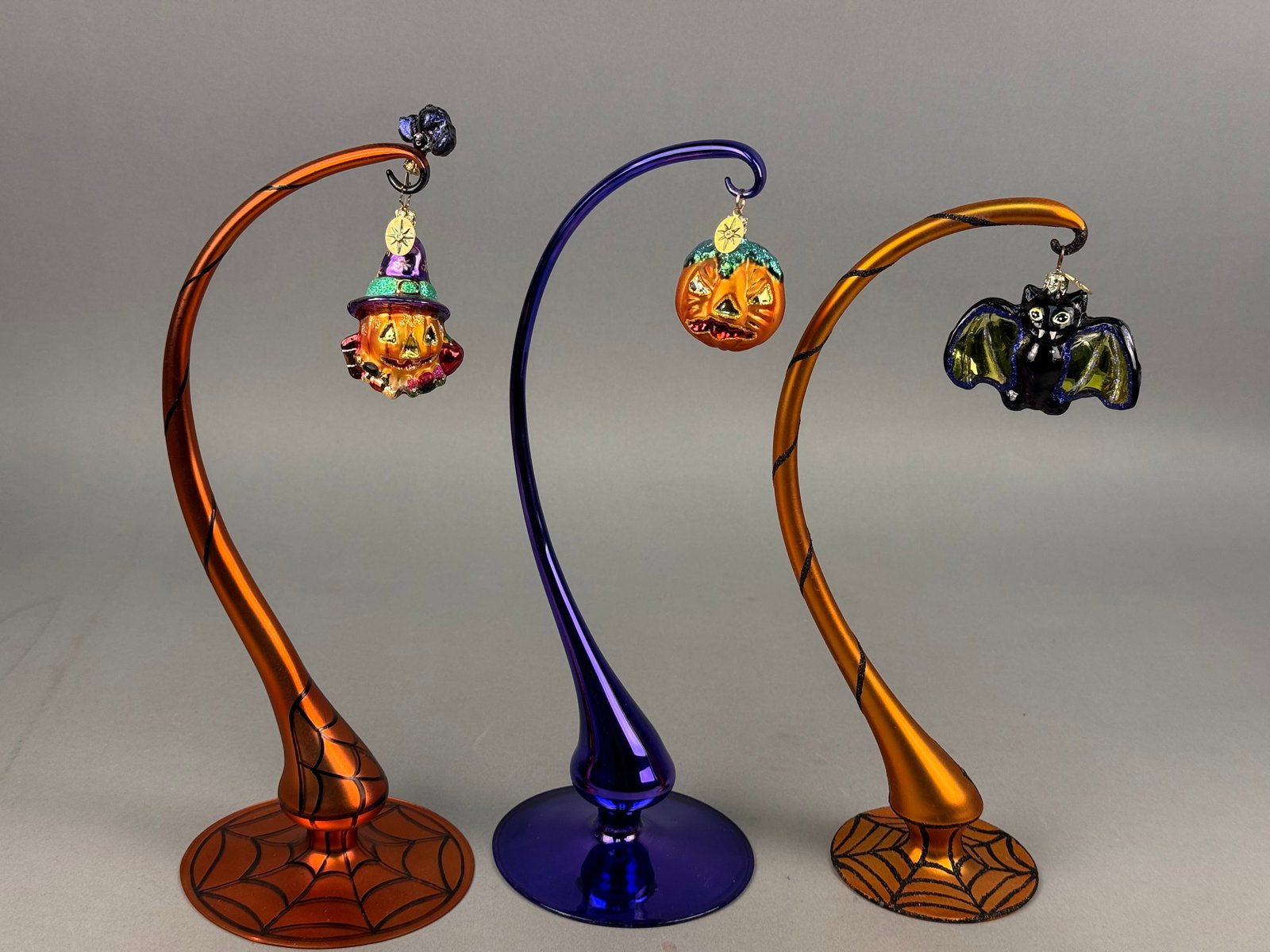 A Trio of Radko Blown Glass Halloween Ornaments: Ornament stands NOT INCLUDED. A collection of three contemporary hand-blown glass holiday ornaments by Christopher Radko. Each ornament is equipped with a gold-toned metal cap embossed with a snowflak