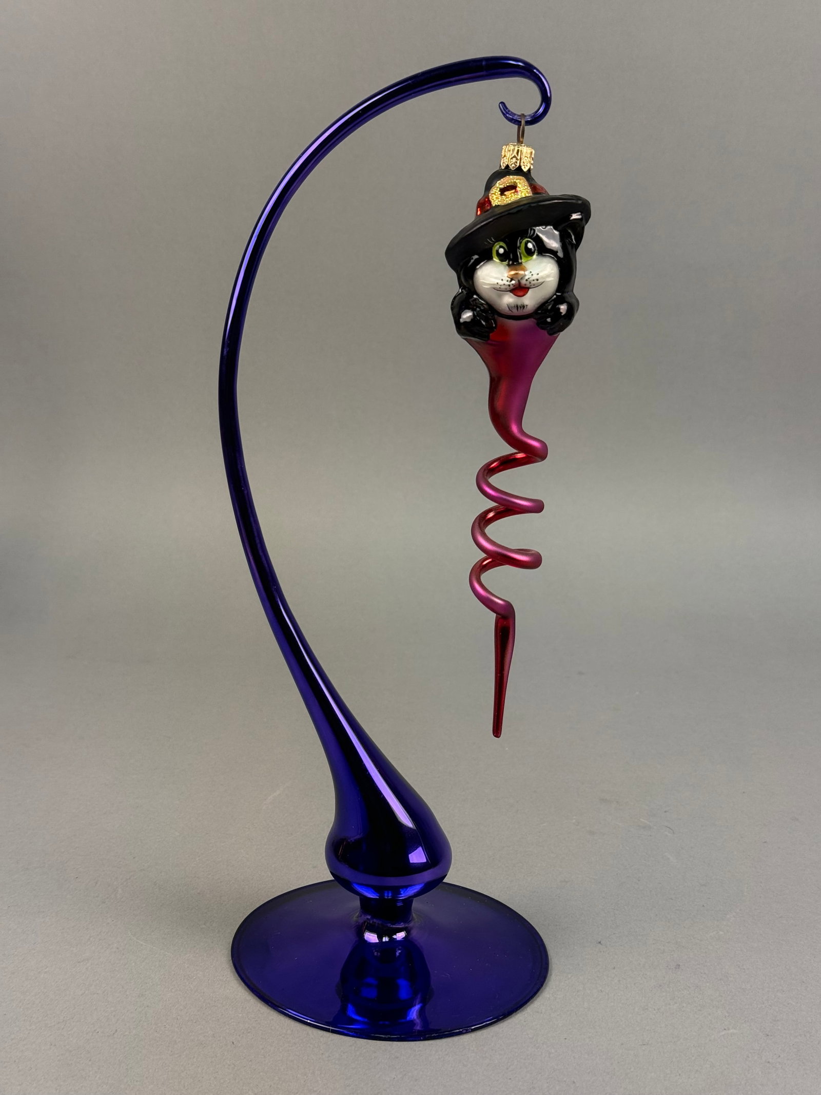Radko Glass Halloween Cat Witch Ornament: Ornament stand NOT INCLUDED. A collectible mouth-blown glass Halloween ornament by Christopher Radko, featuring a whimsical black cat in a witch's hat. figure transitions into an elongated, iridescent