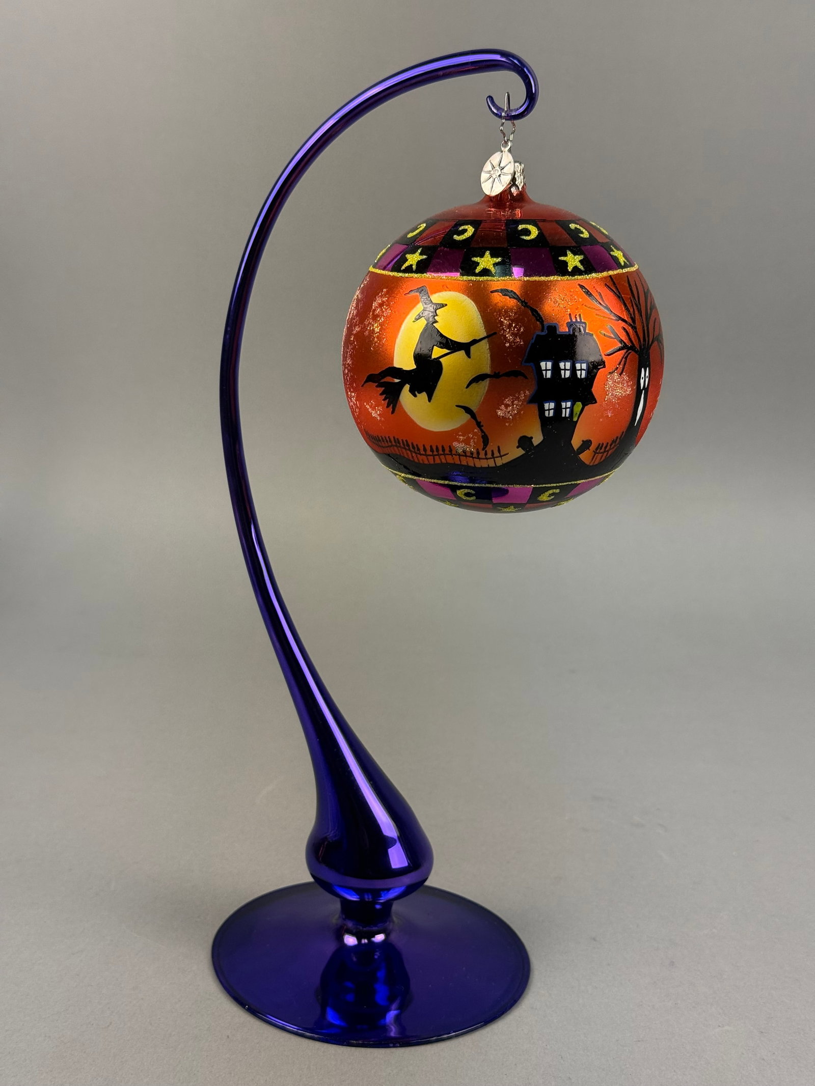 Radko Hand-Blown Glass Halloween Ornament: Ornament stand NOT INCLUDED. Christopher Radko hand-blown glass ornament. The spherical ornament features a vibrant orange pearlescent ground decorated with a hand-painted nocturnal Halloween scene. T