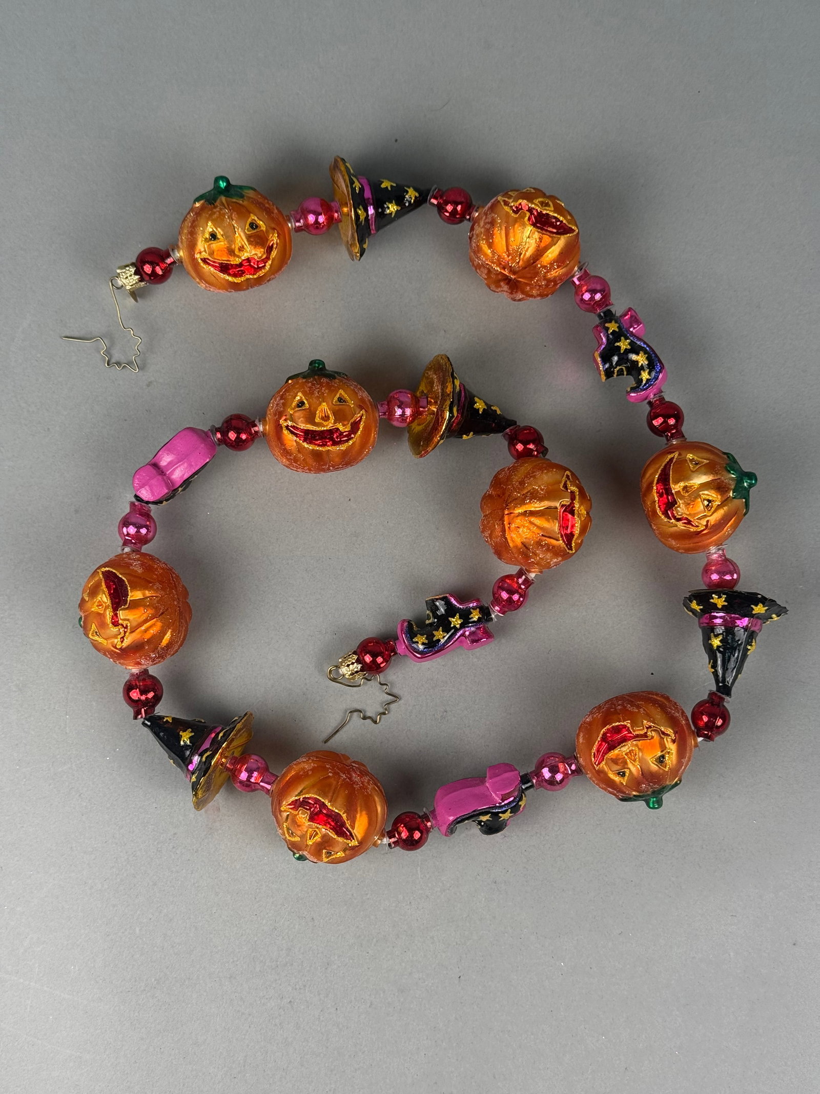 Radko Halloween Spooktacular Blown Glass Garland: A Christopher Radko Halloween-themed glass garland from the Spooktacular collection. The ornaments are connected by wire with metallic red and pink spacer beads and finished with decorative crimped go