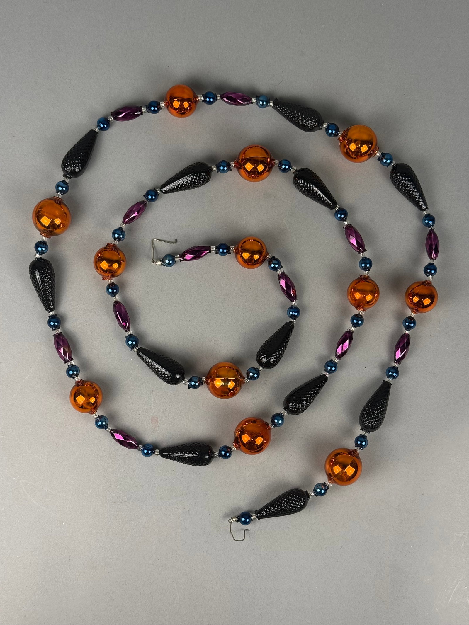 Radko Halloween Glass Bead Garland with Original Box: Christopher Radko decorative Halloween-themed garland comprised of hand-blown and molded glass beads. Each end of the wire-strung garland is finished with a metal S-hook. The item is contained in its 