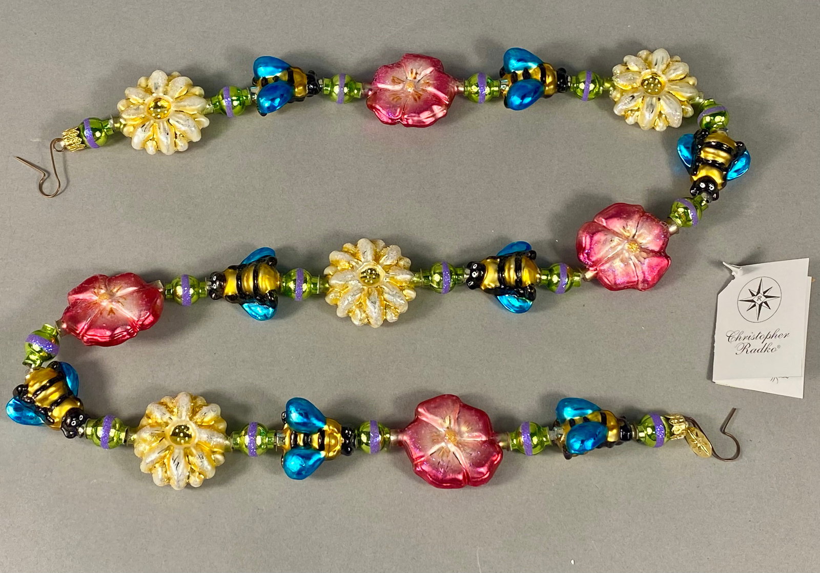 Christopher Radko Bee Blossom Mouth-Blown Glass Garland: A Christopher Radko Bee Blossom mouth-blown glass garland, manufactured in Poland, dated 1999-2000. This decorative garden-themed strand is composed of hand-painted glass beads and figures. The design