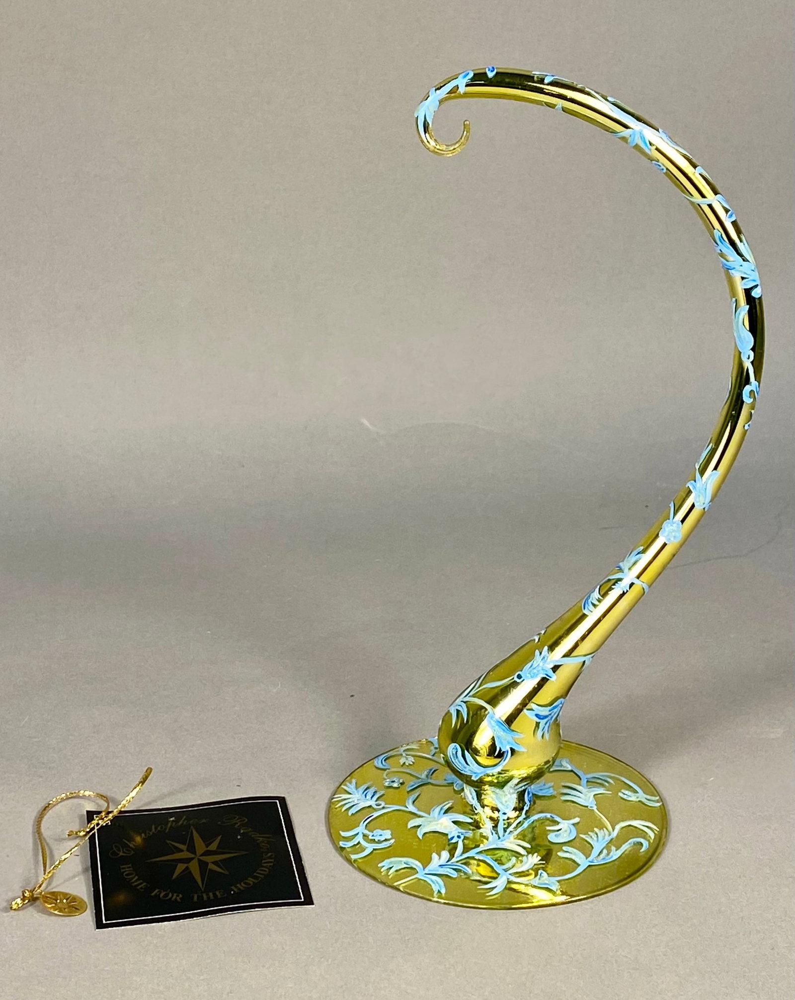 Christopher Radko English Ivy Blown Glass Ornament Stand: This Christopher Radko ornament stand, titled English Ivy, is part of the Home for the Holidays collection. The piece is crafted from blown glass with a gold-toned metallic finish and features hand-pa