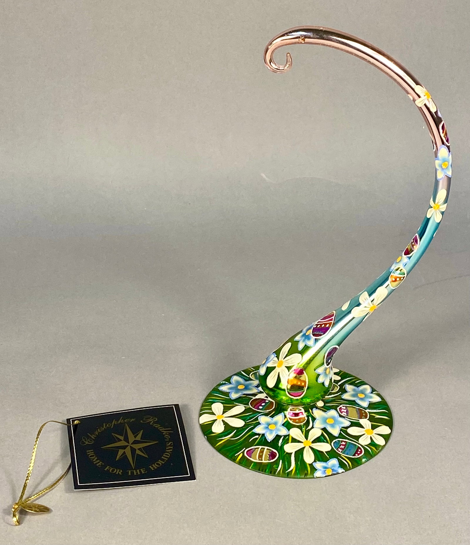 Christopher Radko Florentine Flair Hand-Painted Blown Glass Ornament Stand: This hand-painted blown glass ornament stand is from the Christopher Radko Home for the Holidays collection in the Florentine Flair pattern. The piece features a circular base and an elegantly curved,