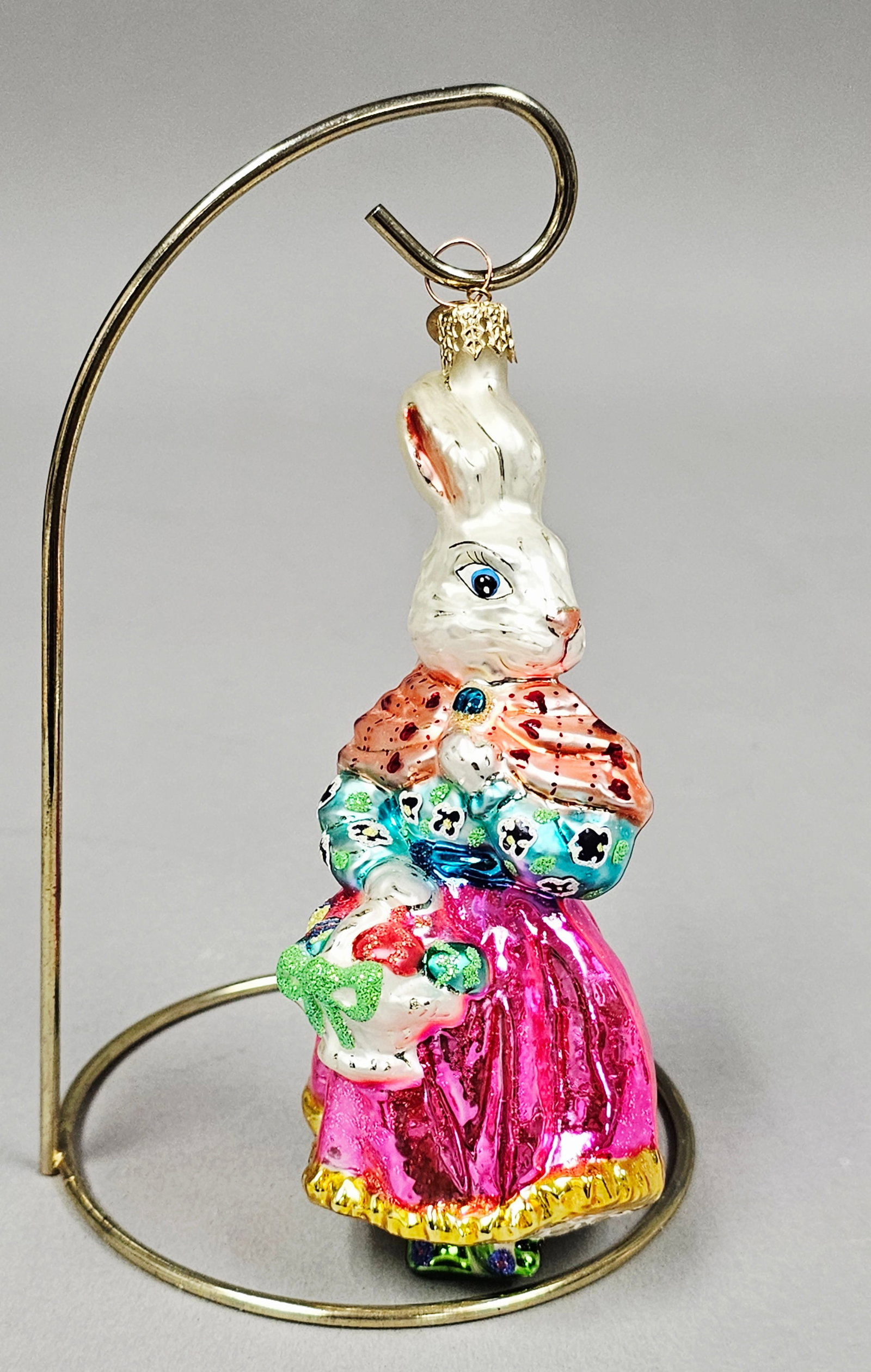 Vintage-Style Hand-Blown Glass Bird on Rose Clip-On Christmas Ornament: This hand-blown glass Christmas ornament features a stylized bird perched atop a blooming rose. The ornament is designed as a clip-on with a gold-toned, spring-loaded metal attachment. The bird's body