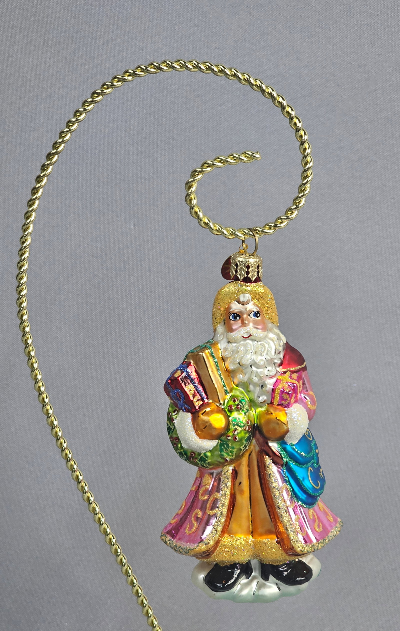 Christopher Radko Hand-Blown Glass Santa Claus Christmas Ornament: This hand-blown and silvered glass Christmas ornament is produced by Christopher Radko, identified by the trademark embossed eight-pointed star charm attached to the hanging ring. The ornament depicts
