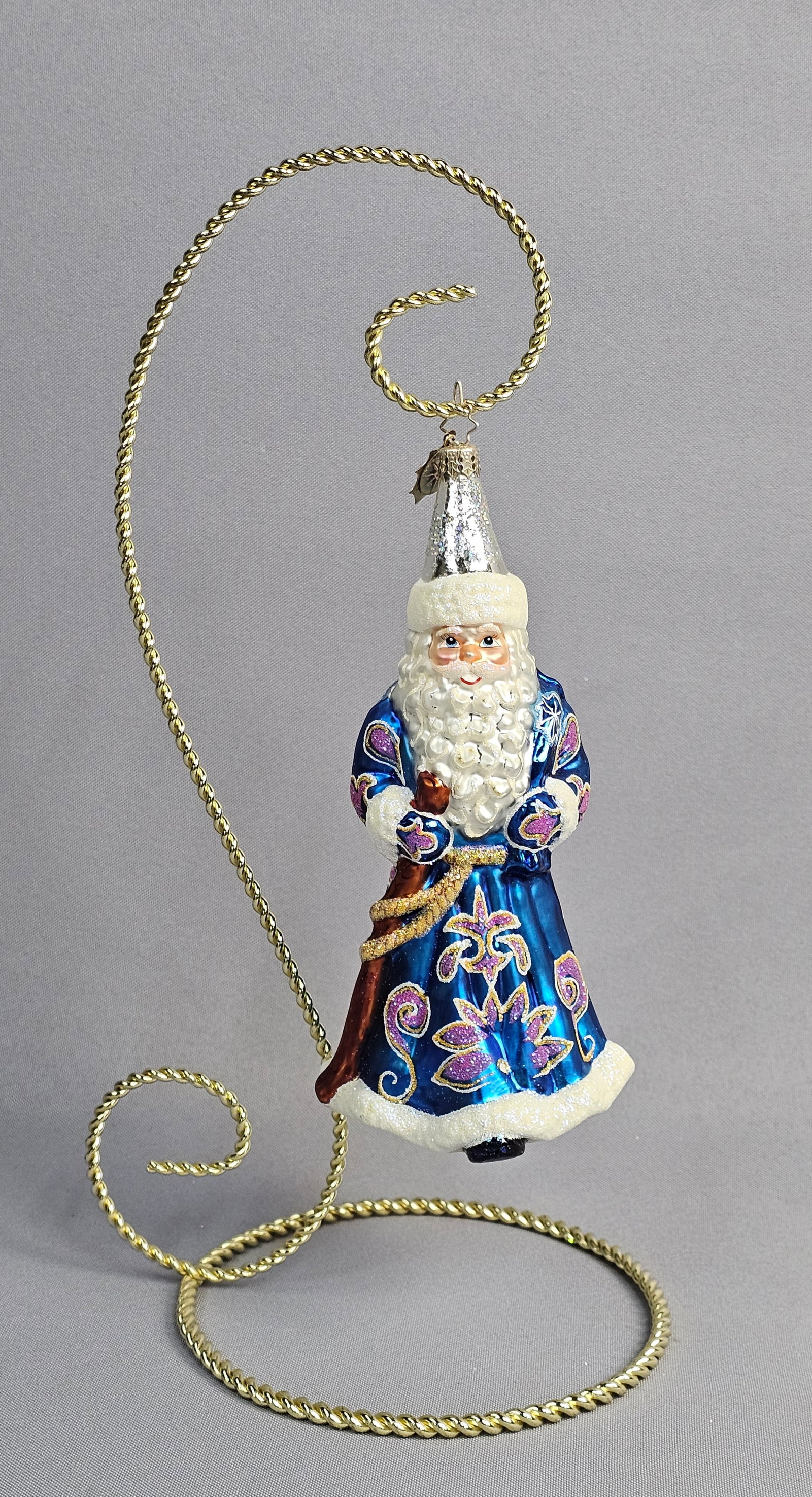 Christopher Radko Hand-Painted Glass Father Christmas Ornament with Stand: A hand-blown glass Christmas ornament by Christopher Radko depicting a Father Christmas or Ded Moroz figure. The standing figure is dressed in a vibrant cobalt blue coat featuring hand-painted gold-to