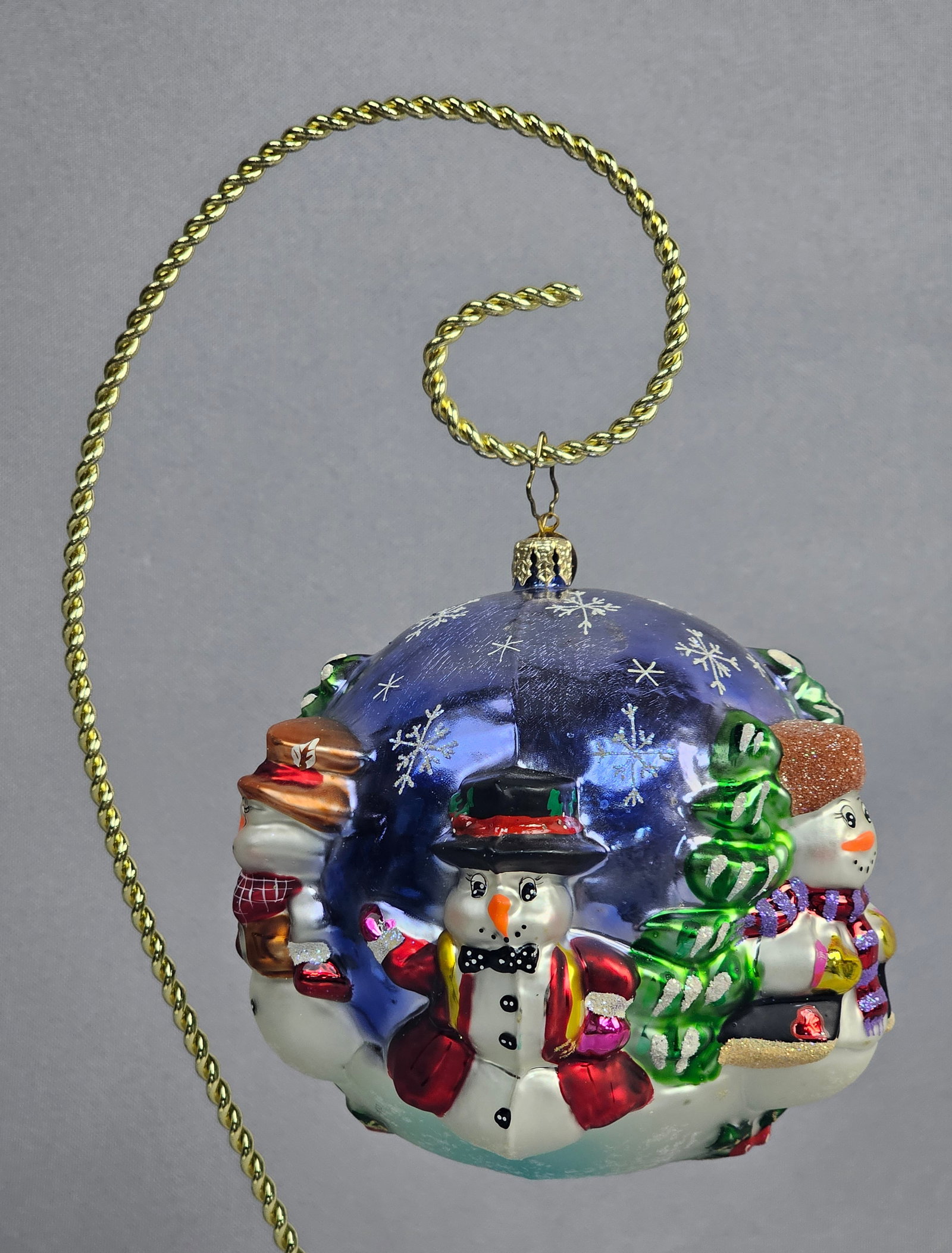 Large Polish Mouth-Blown Glass Snowman Wonderland Relief Ball Ornament: Large mouth-blown glass Christmas ball ornament featuring a high-relief Snowman Wonderland scene. This piece is produced in Poland, with the gold-toned metal hanging cap embossed with the text POLONIA