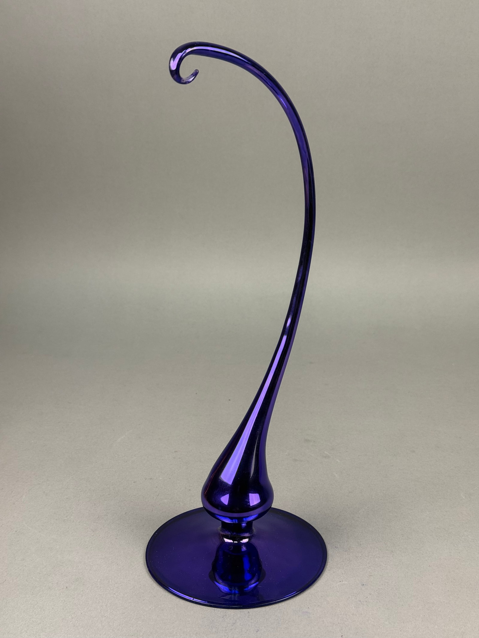Cobalt Blue Art Glass Ornament Stand Attributed to Christopher Radko: This hand-blown art glass ornambase features a polished pontil mark. No maker marks or signatures are visible. Base Diameter: 5 inches Overall Height: 12.5 inches. The item is in excellent condition. 