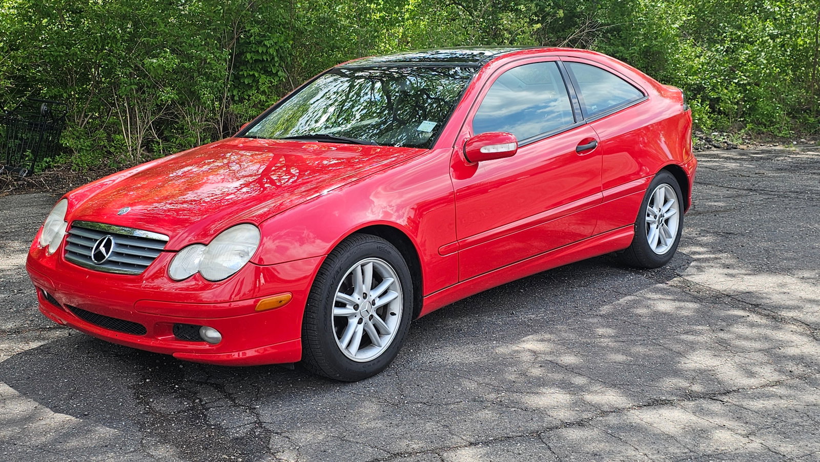 2002 Mercedes-Benz C230 Kompressor Sports Coupe: This 2002 Mercedes-Benz C230 Kompressor Sports Coupe is a two-door hatchback finished in red over a charcoal fabric interior. Power is provided by a 2.3-liter supercharged inline-four engine paired