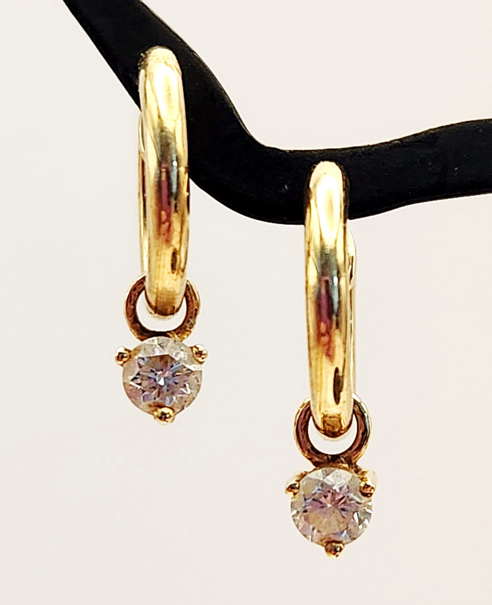 14K Gold Hoop Earrings 2.3 Grams: 14K gold huggie hoop design with dangling accent diamonds. Weight: 2.3 grams Length: Approximately 0.75 inches. The earrings are in good condition with minor surface wear and light scratches