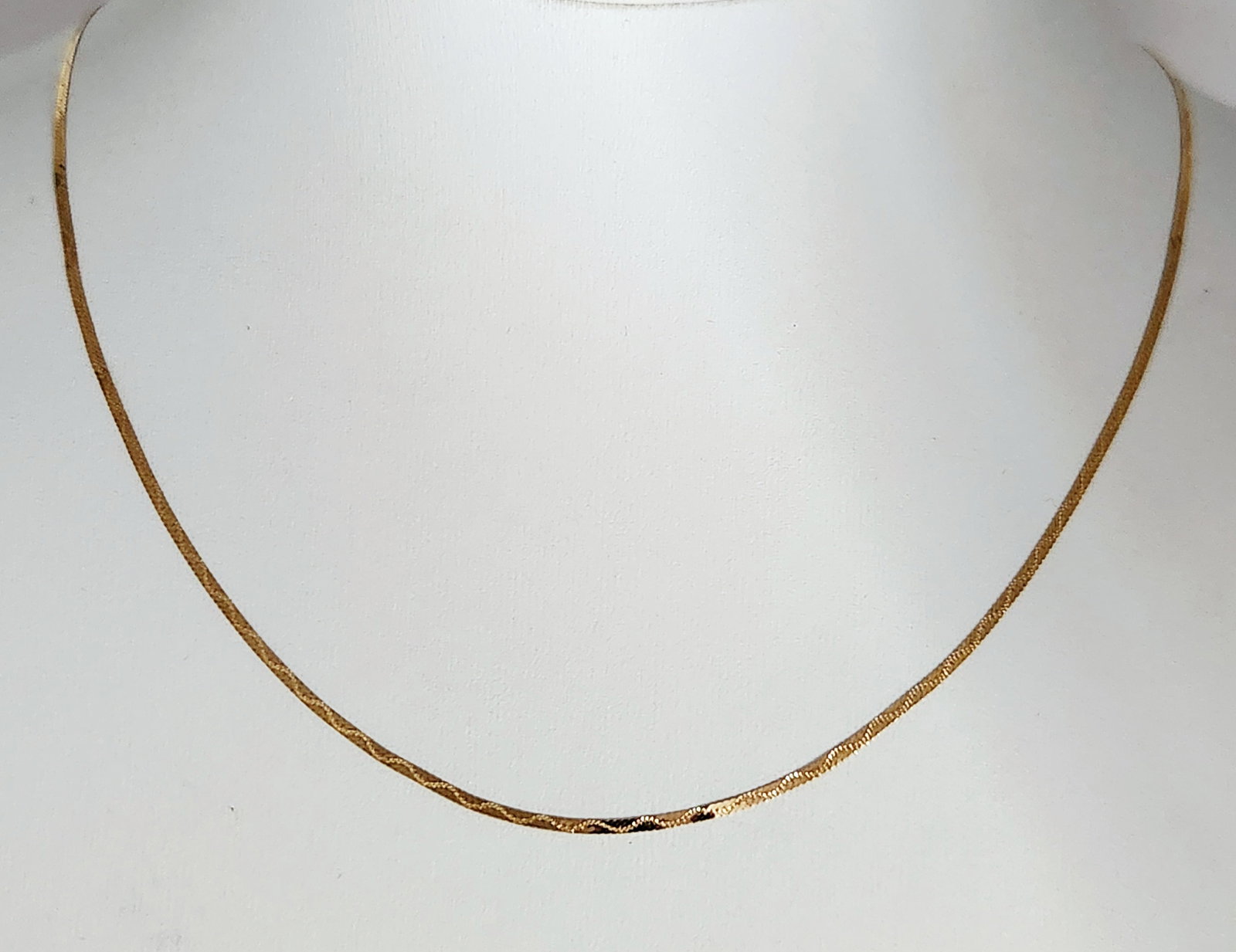 14K Gold Herringbone Necklace 1.3 Grams: This flat herringbone link necklace chain is crafted in 14 karat yellow gold and features a polished finish. Weight: 1.3 grams Length: 18 inches. The necklace is in good overall condition, showing