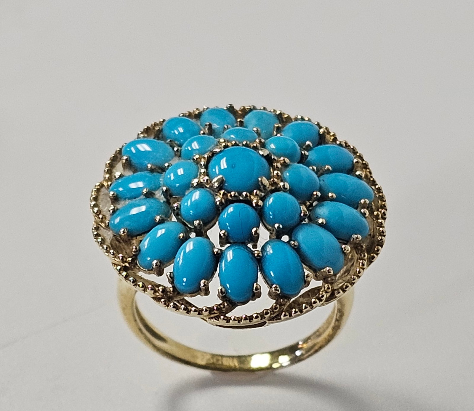 Gold Washed Sterling Turquoise Ring: A turquoise cluster cocktail ring. The interior of the band is stamped with a four-pointed star maker's mark followed by the numerals 925 and CHINA. Ring Size: US 6 Weight: Approximately 5.3 grams.