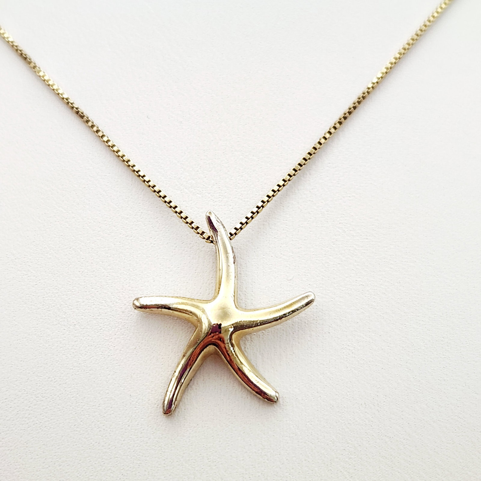 Vermeil Starfish Necklace 4.3 Grams: A yellow gold-plated sterling silver necklace featuring a starfish-shaped pendant on a box-link chain. Chain length: Approximately 15 inches Pendant width: Approximately 0.75 inches Total weight: Appr