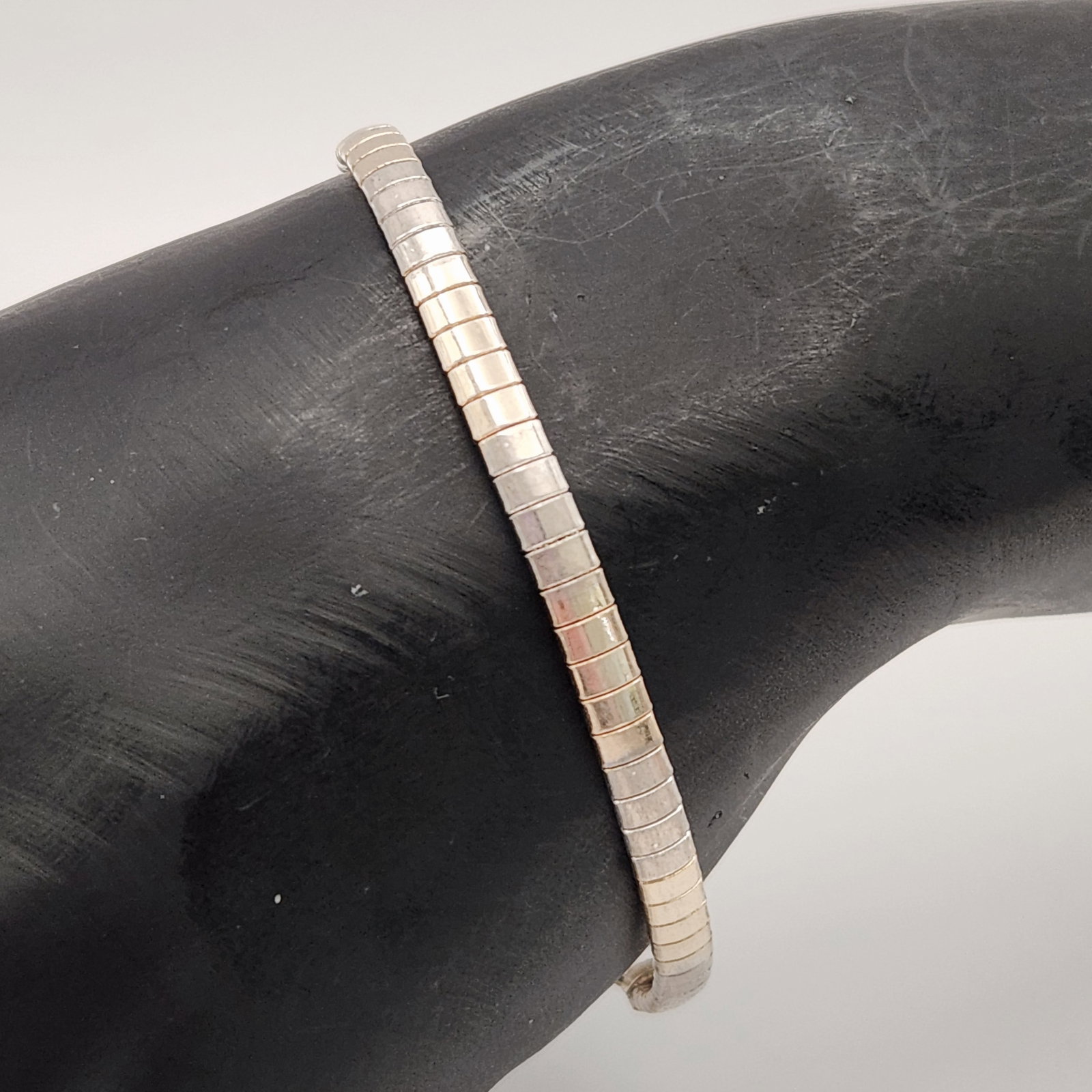 Vermeil & Sterling Silver Bracelet 9.2 Grams: This lot features a flexible link bracelet in a tubogas or cobra-link style, constructed with square segments. Length: 7 inches Weight: 9.2 grams. The bracelet is in good overall condition with some