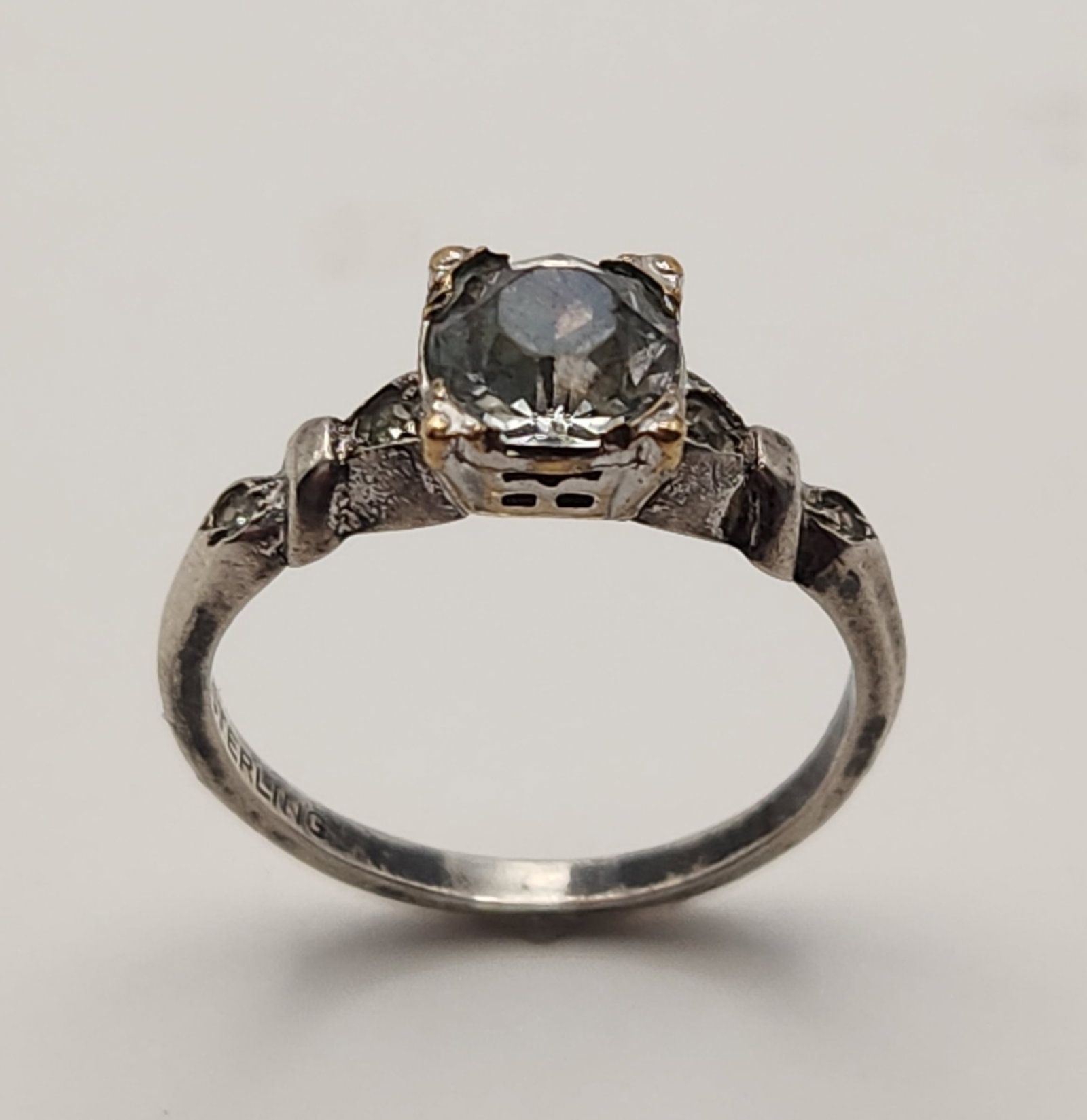Vintage Sterling Crystal Ring: The interior of the band is stamped with the characters STERLING preceded by a maker mark consisting of a capital letter H inside a diamond-shaped border. Size: 7.5 Weight: 2.5 grams. The metal shows 