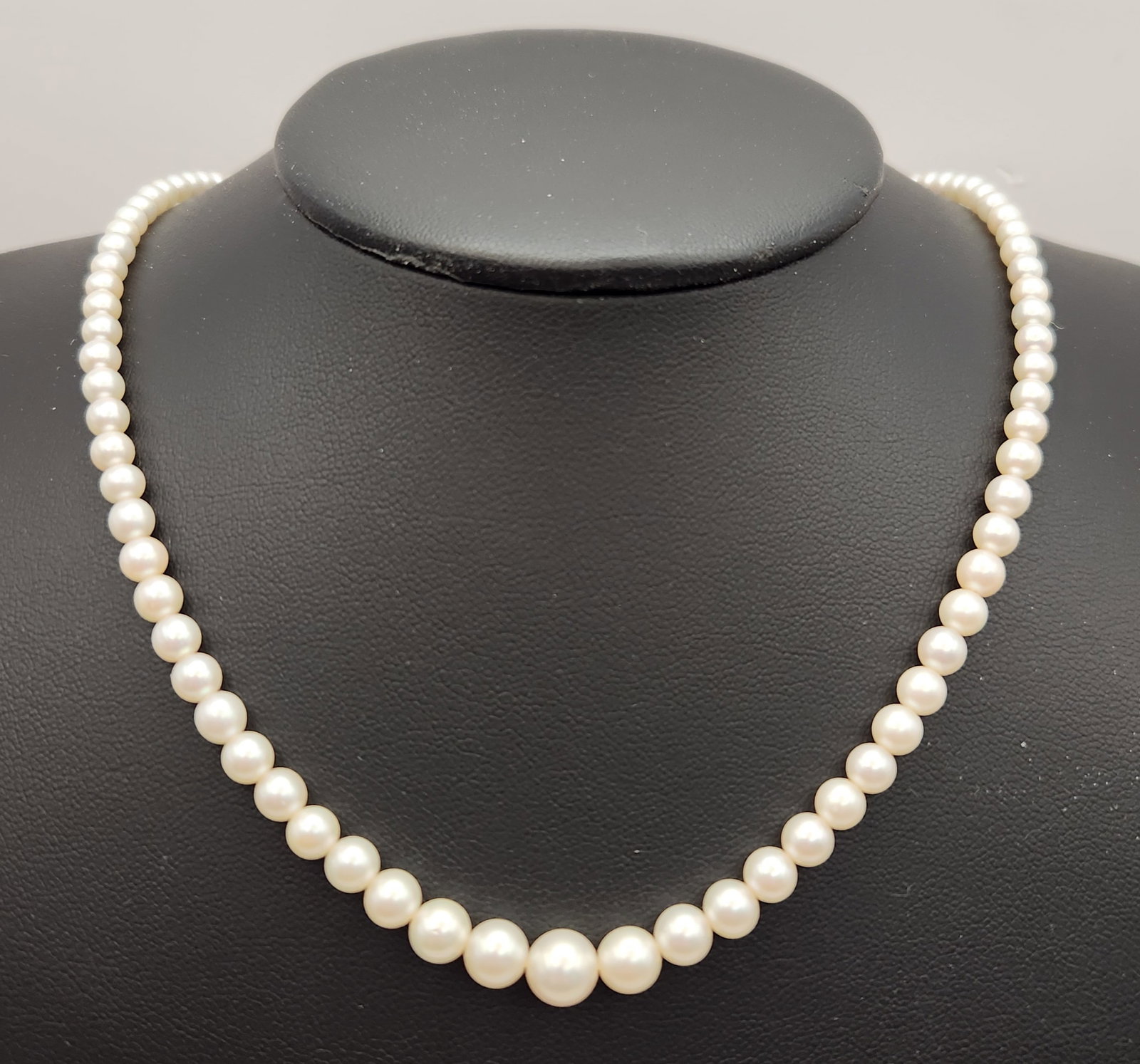 Graduated Pearl Necklace Sterling Clasp: A vintage graduated pearl necklace featuring cream-colored pearls with soft luster and pinkish overtones. The pearls are individually knotted on a white silk cord. Length: 17 inches Pearl diameter: ap