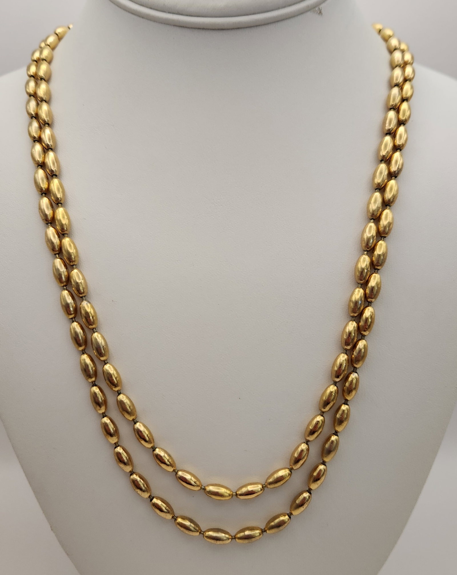 Napier Gold-Tone Necklace: The piece is constructed of gold-tone base metal and features a continuous series of elongated oval beads, often referred to as rice beads. Overall Length: 62 inches Individual Bead Length: Approximat