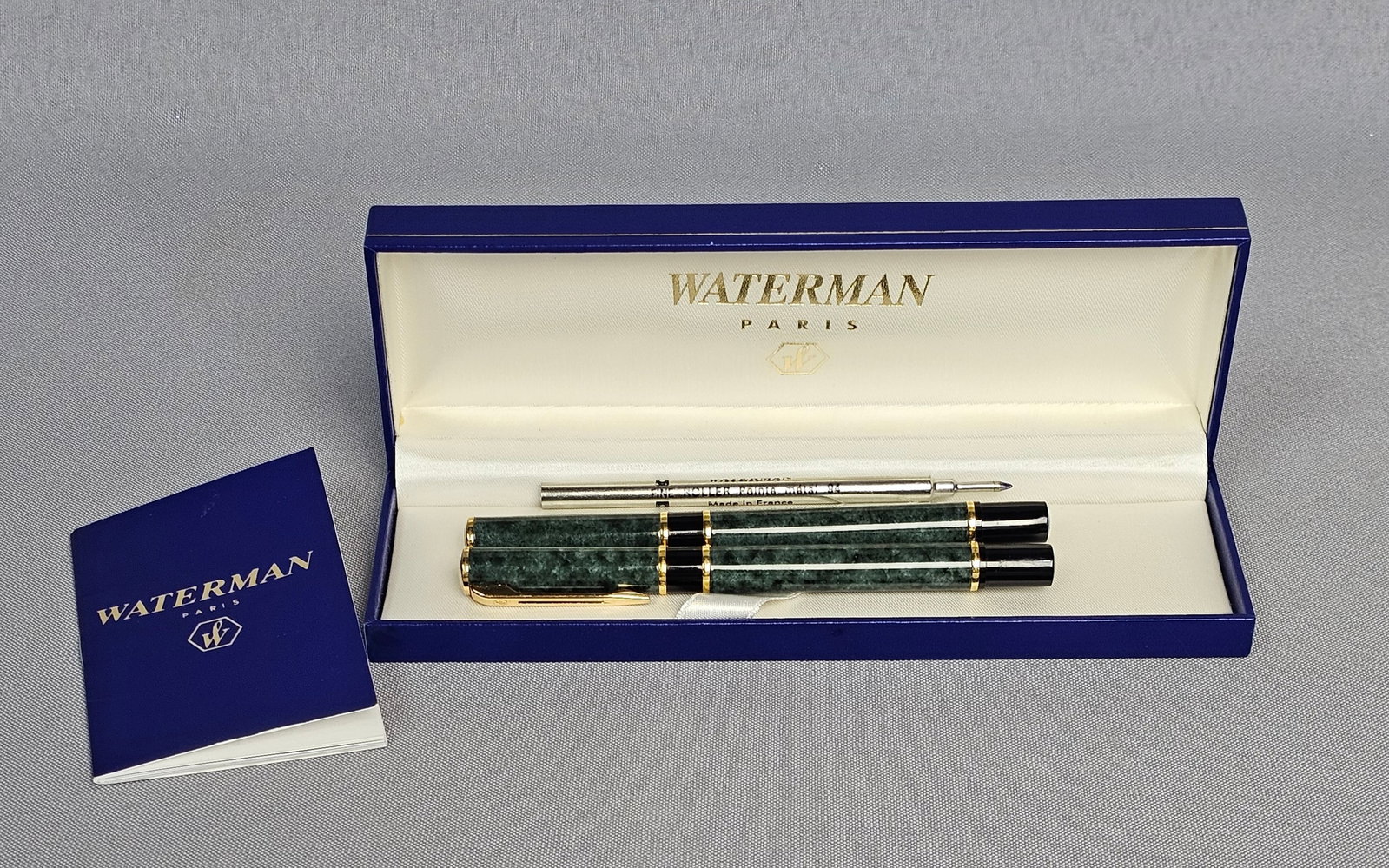 Waterman Green Marble Pen Set: A Waterman Laureat writing instrument set comprising a fountain pen and a matching rollerball pen. Both instruments feature a green marble pattern finish with gold-plated trim and black resin