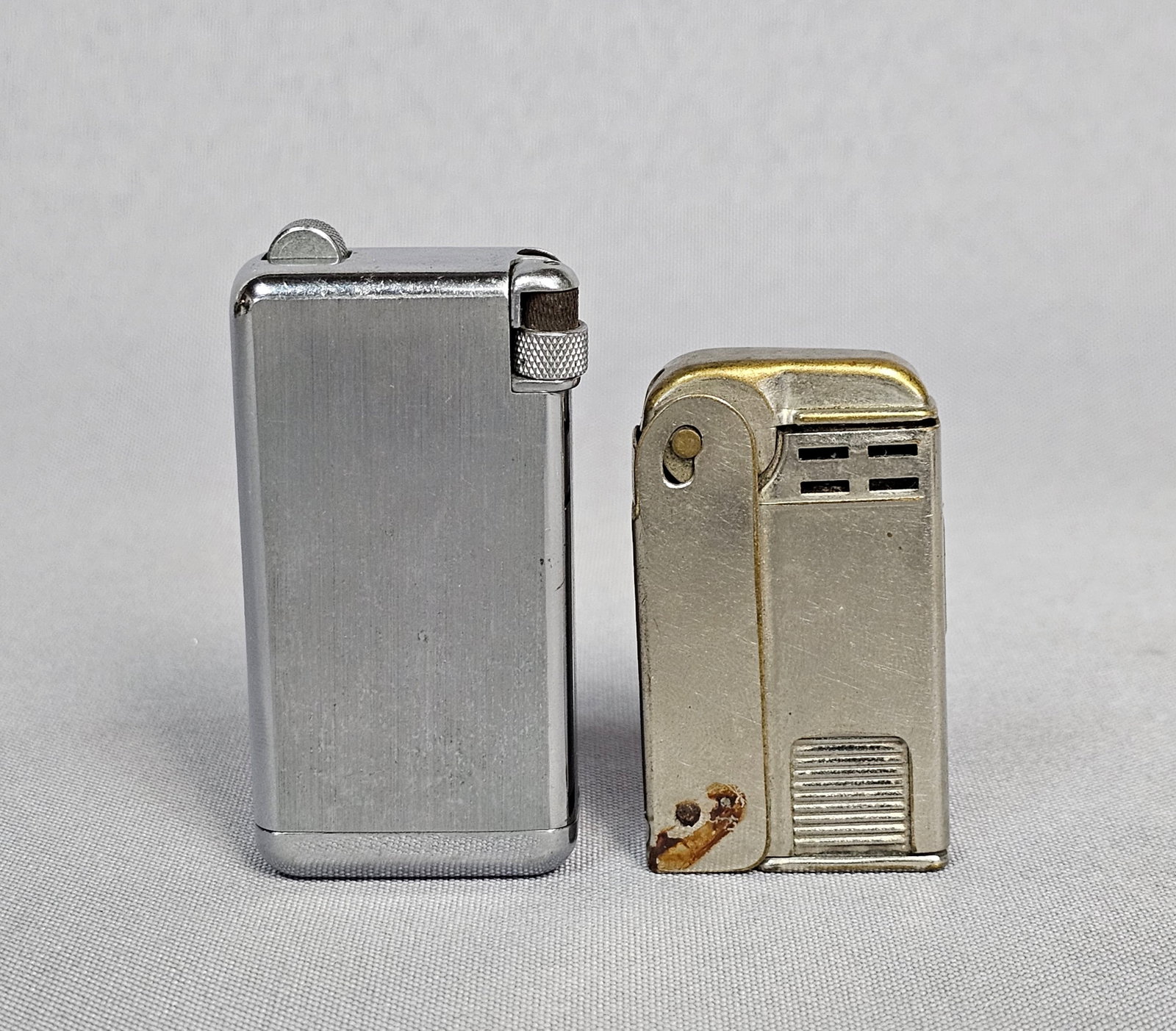 Two Vintage Pocket Lighters: This lot features two mid-century American-made metal cigarette lighters. The first is a Parker Flaminaire produced by the Parker Pen Company, featuring a brushed silver-toned rectangular body. The