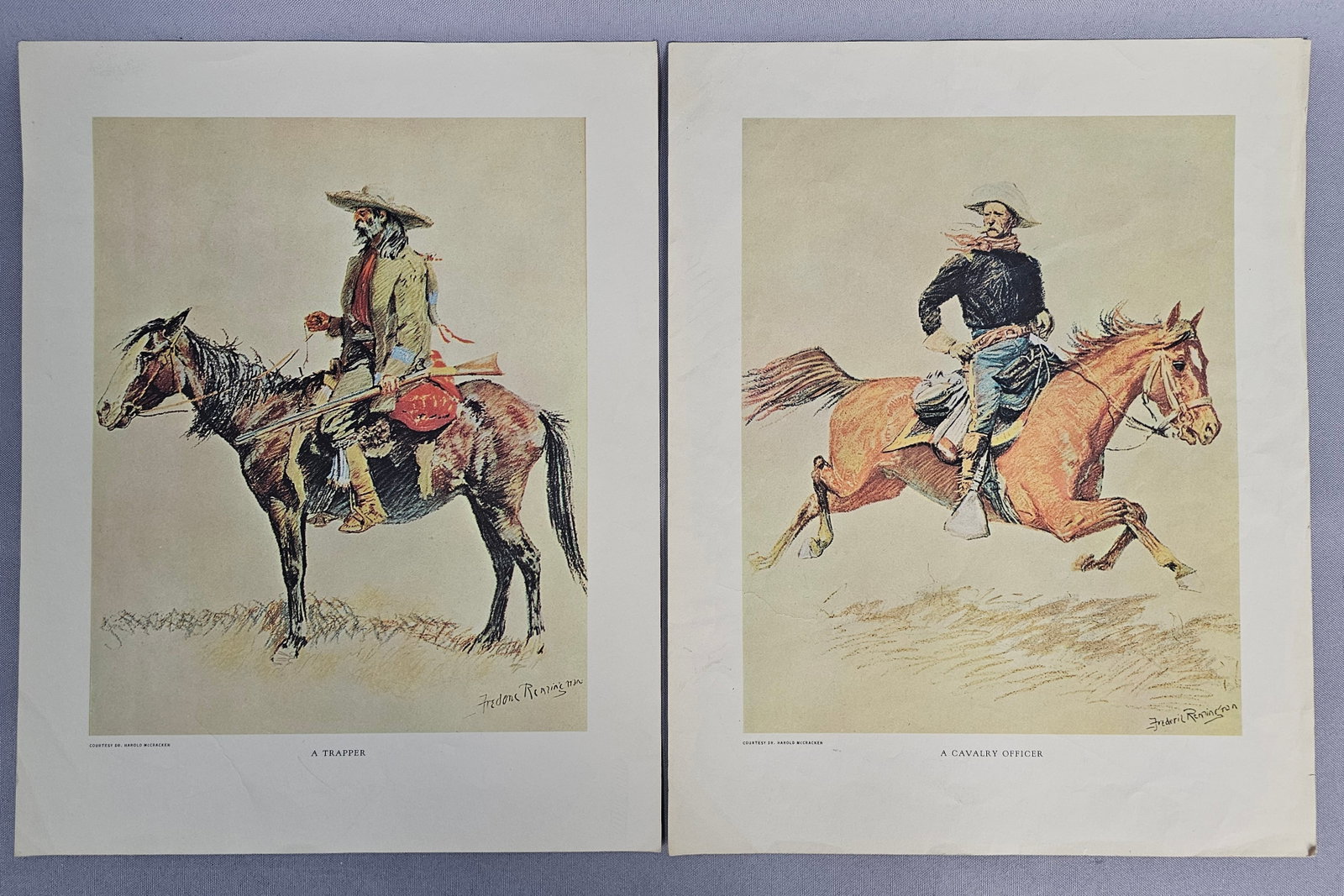 Frederic Remington Color Prints A Trapper & Cavalry Officer: A pair of color lithographic reproductions depicting classic Western subjects after original works by Frederic Remington. The prints are titled A Trapper and A Cavalry Officer in the lower margin. No