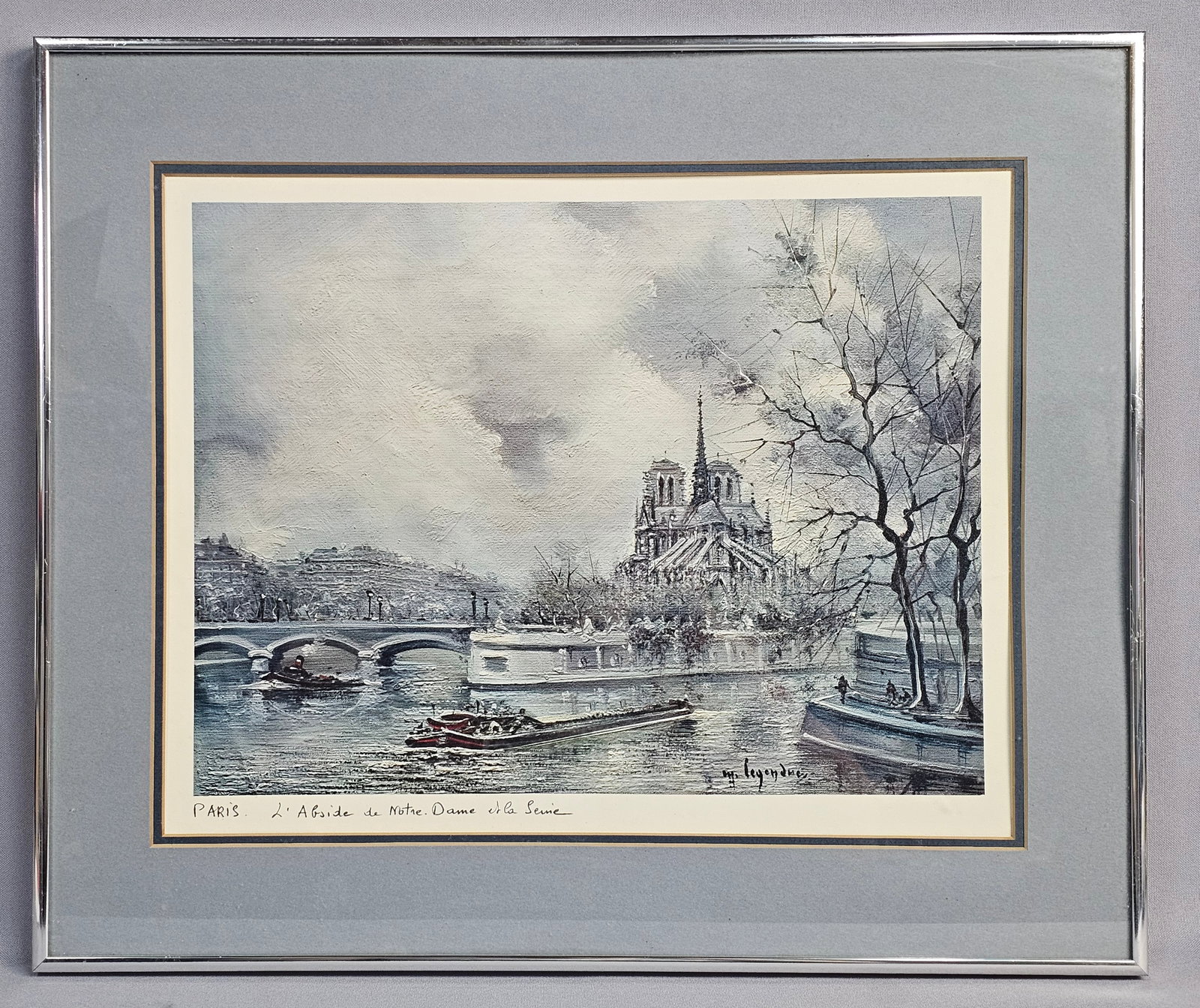 Maurice Legendre Framed Lithograph: This mid-20th-century impressionistic cityscape print is by the French artist Maurice Legendre titled Paris L' Abside de Notre Dame et la Seine. The artwork is presented in a modern silver-toned