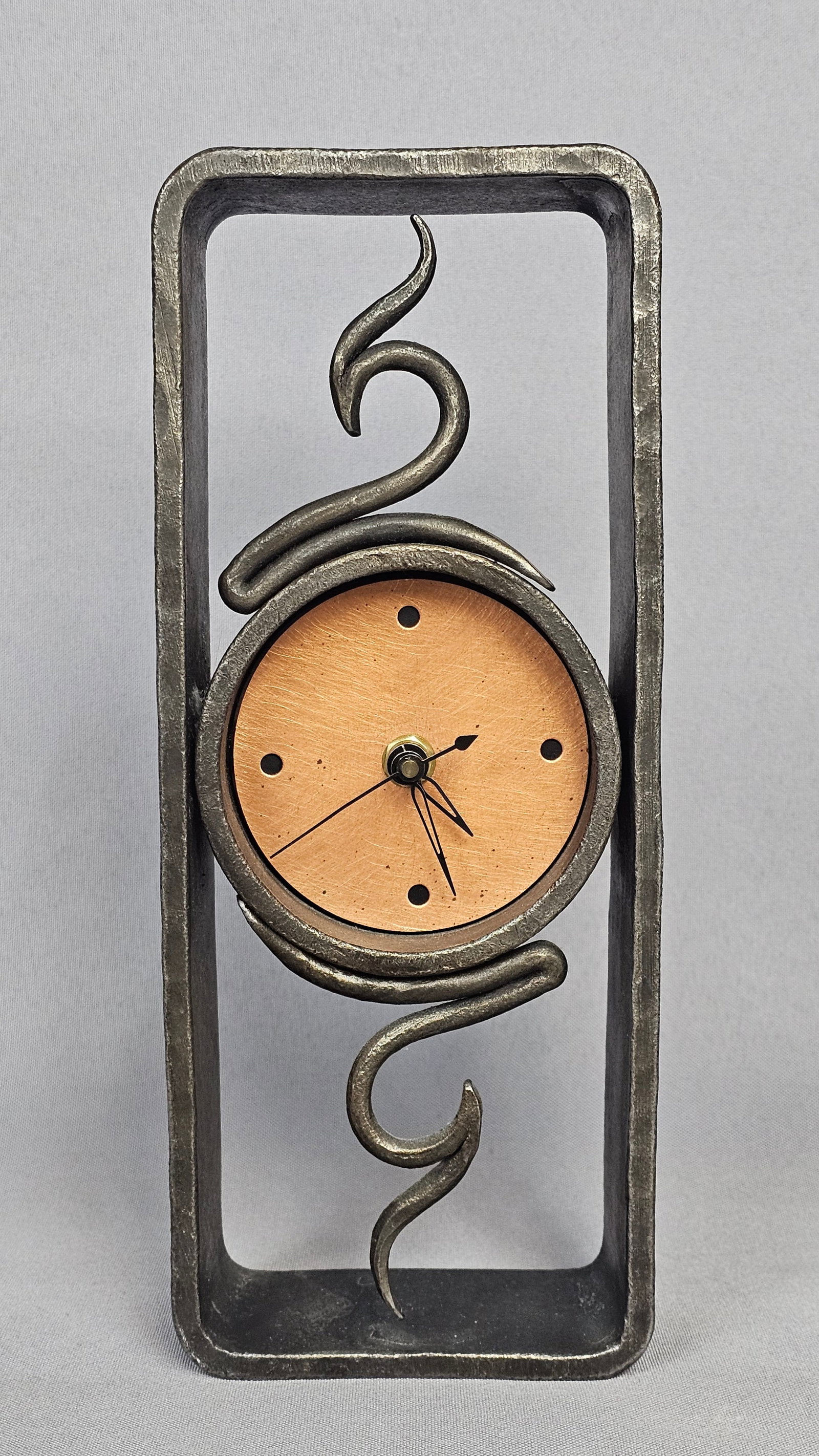 Blackthorne Forge Studio Iron & Copper Clock: This artisan studio mantel clock is the work of Steven Bronstein for Blackthorne Forge. The piece is constructed with a hand-forged iron rectangular frame featuring a heavily textured and hammered
