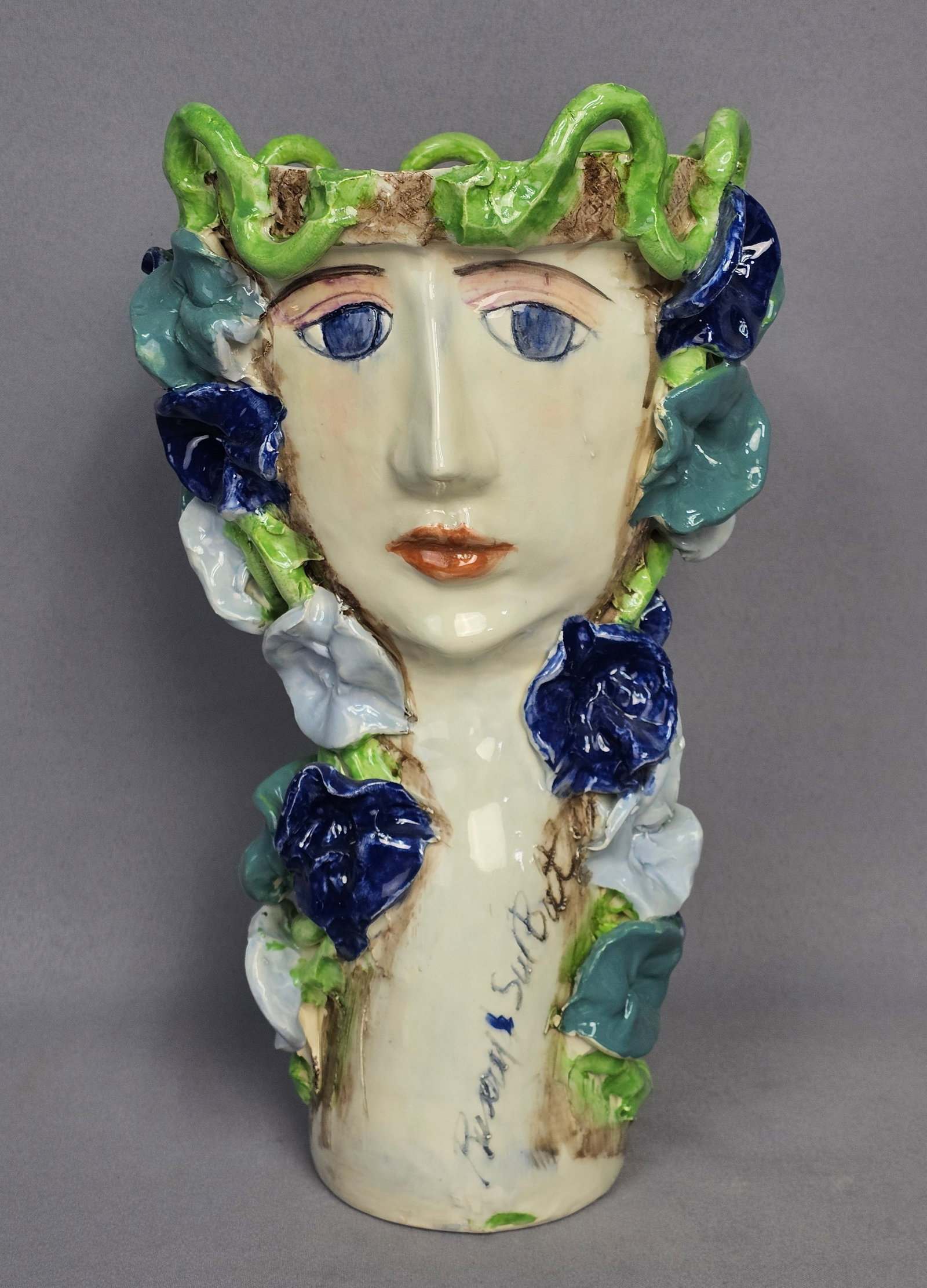 Sue Bolt Large Pottery Vase: A large, hand-modeled glazed earthenware head vase featuring the stylized face of two women. The piece is decorated with hand-painted facial features, including blue eyes and orange lips, under a
