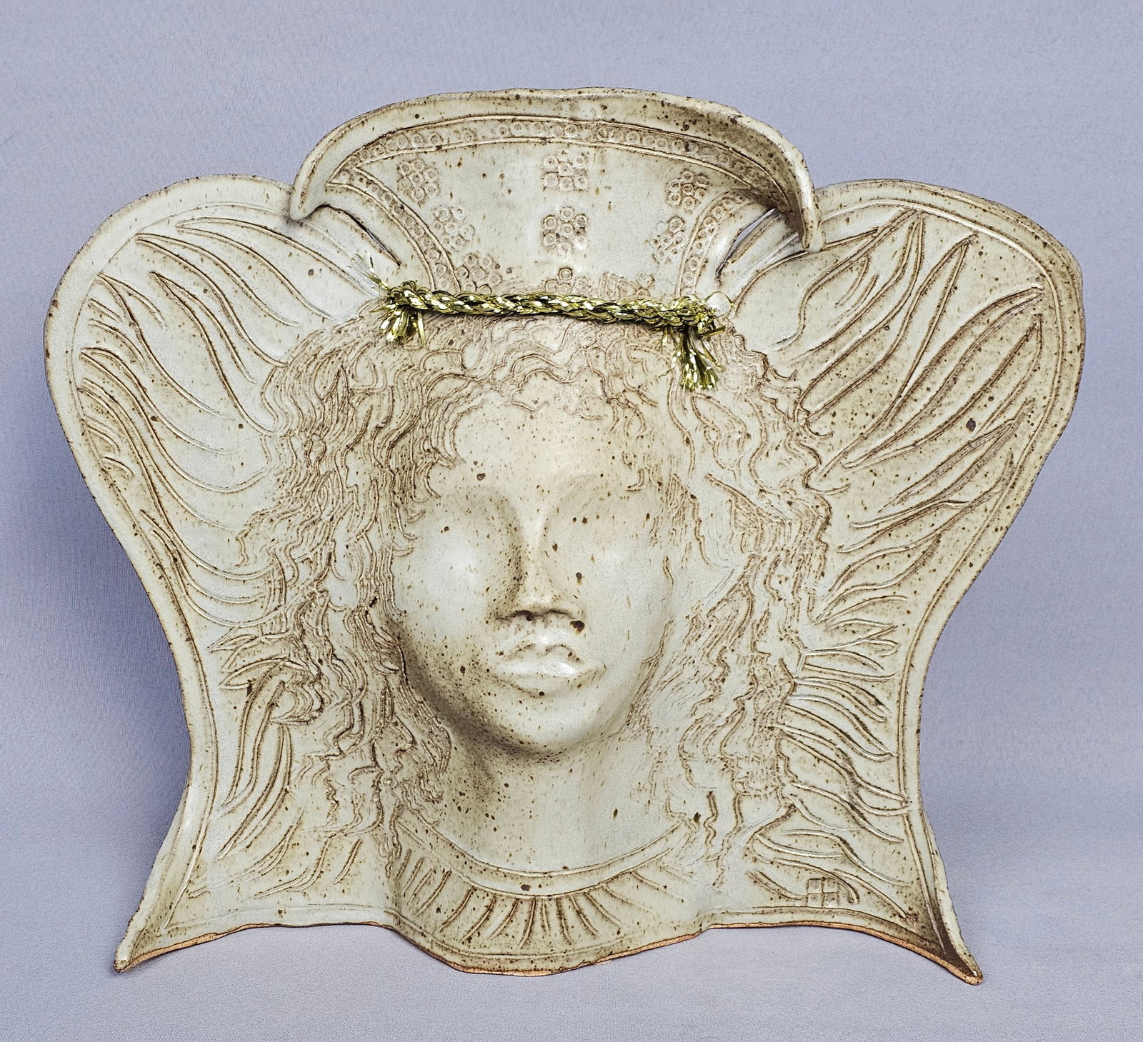 Mary Humphrey Studio Stoneware Female Face Wall Mask: This studio ceramic wall mask is the work of Michigan artist Mary Humphrey. The stoneware piece features a stylized female face with a serene expression and closed eyes, positioned centrally within a 