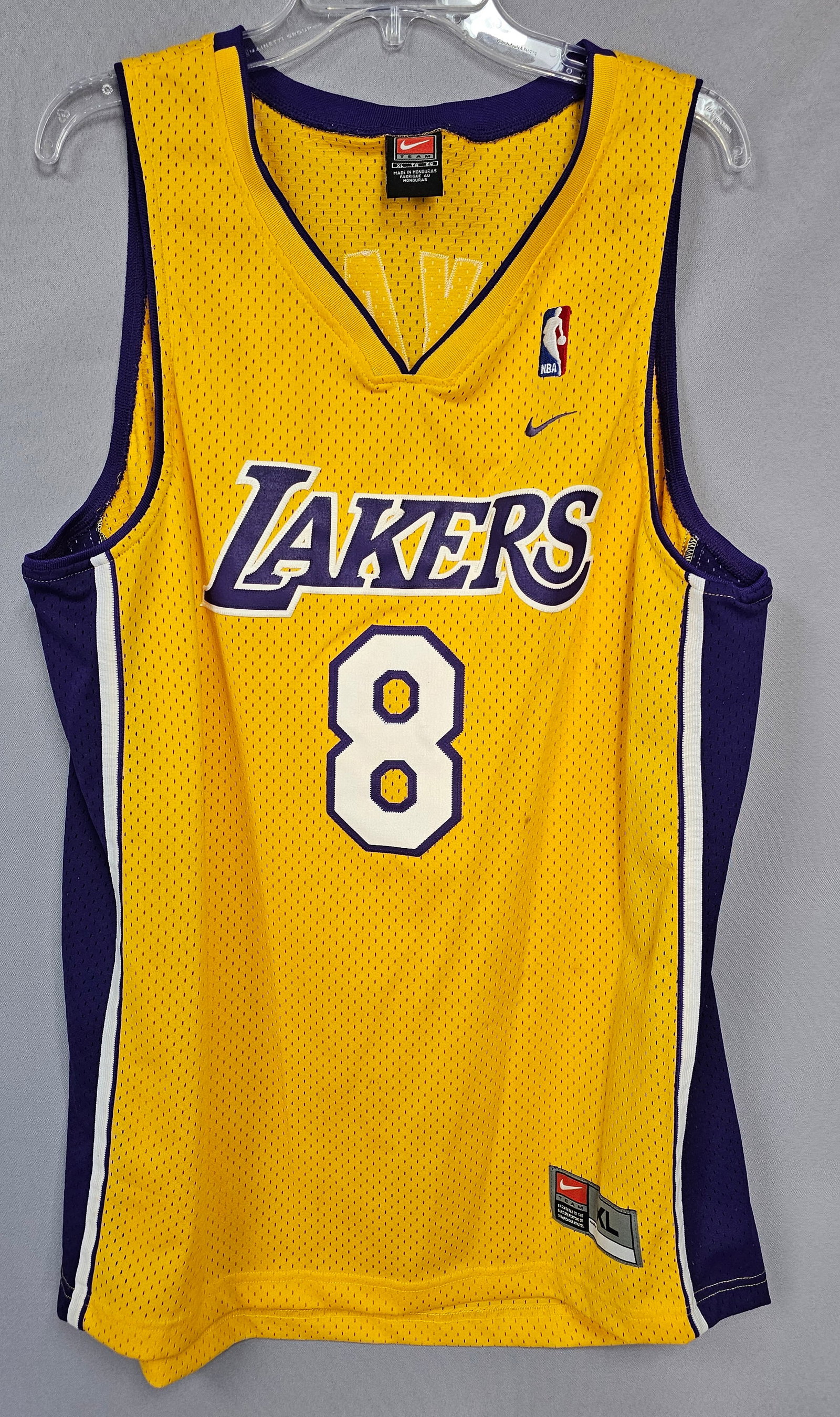 Nike Kobe Bryant Lakers Number 8 Home Basketball Jersey: This Nike Team brand sleeveless basketball jersey represents the Los Angeles Lakers home colorway, featuring the name and number of player Kobe Bryant. The garment is constructed from yellow