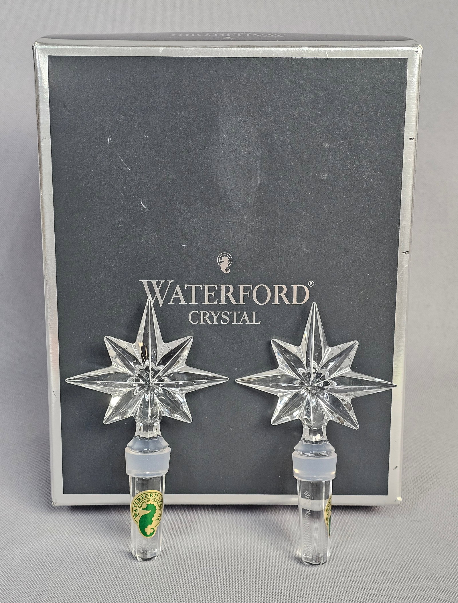 Waterford Crystal Congratulation Bottle Stoppers: A pair of lead crystal bottle stoppers manufactured by Waterford Crystal. Each stopper is designed with a clear, multi-faceted top in an eight-pointed starburst configuration, providing high brillianc