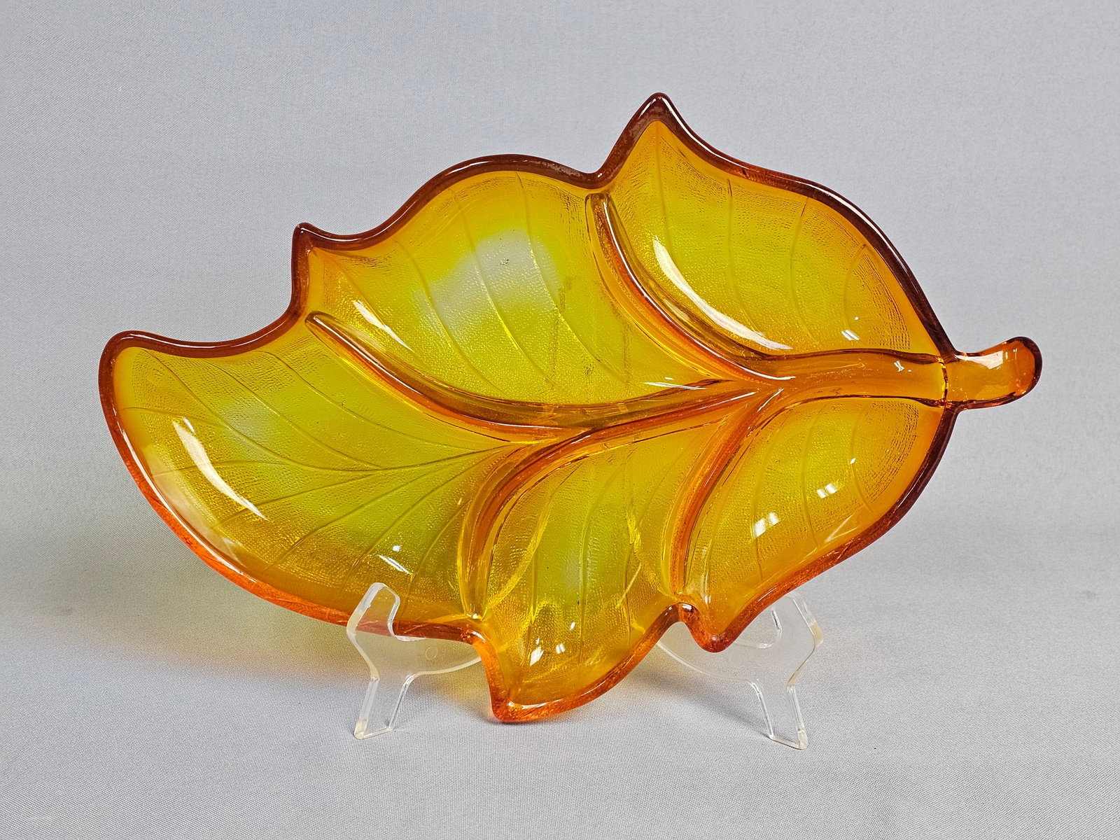Amberina Pressed Glass Scalloped Leaf Serving Dish: This vintage pressed glass dish is designed in the form of a stylized leaf, featuring a transitional color gradient known as amberina, moving from a yellow-gold center to deep orange-red scalloped