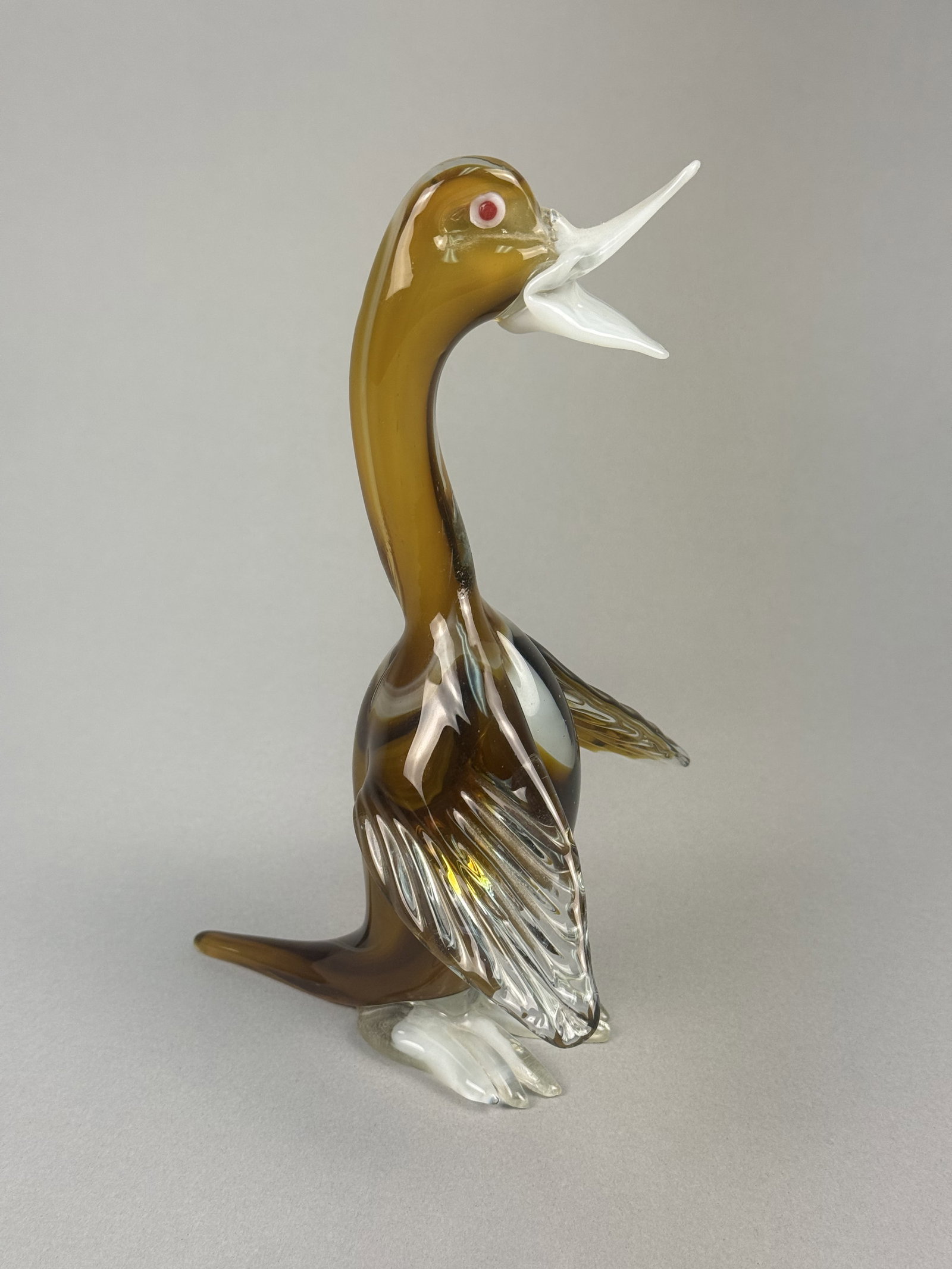 MCM Murano-Style Art Glass Squawking Duck Figurine: This mid-century modern art glass figurine, attributed to the style of Murano glasshouses, depicts a duck or goose in an animated squawking pose with an open beak and spread wings. The piece is