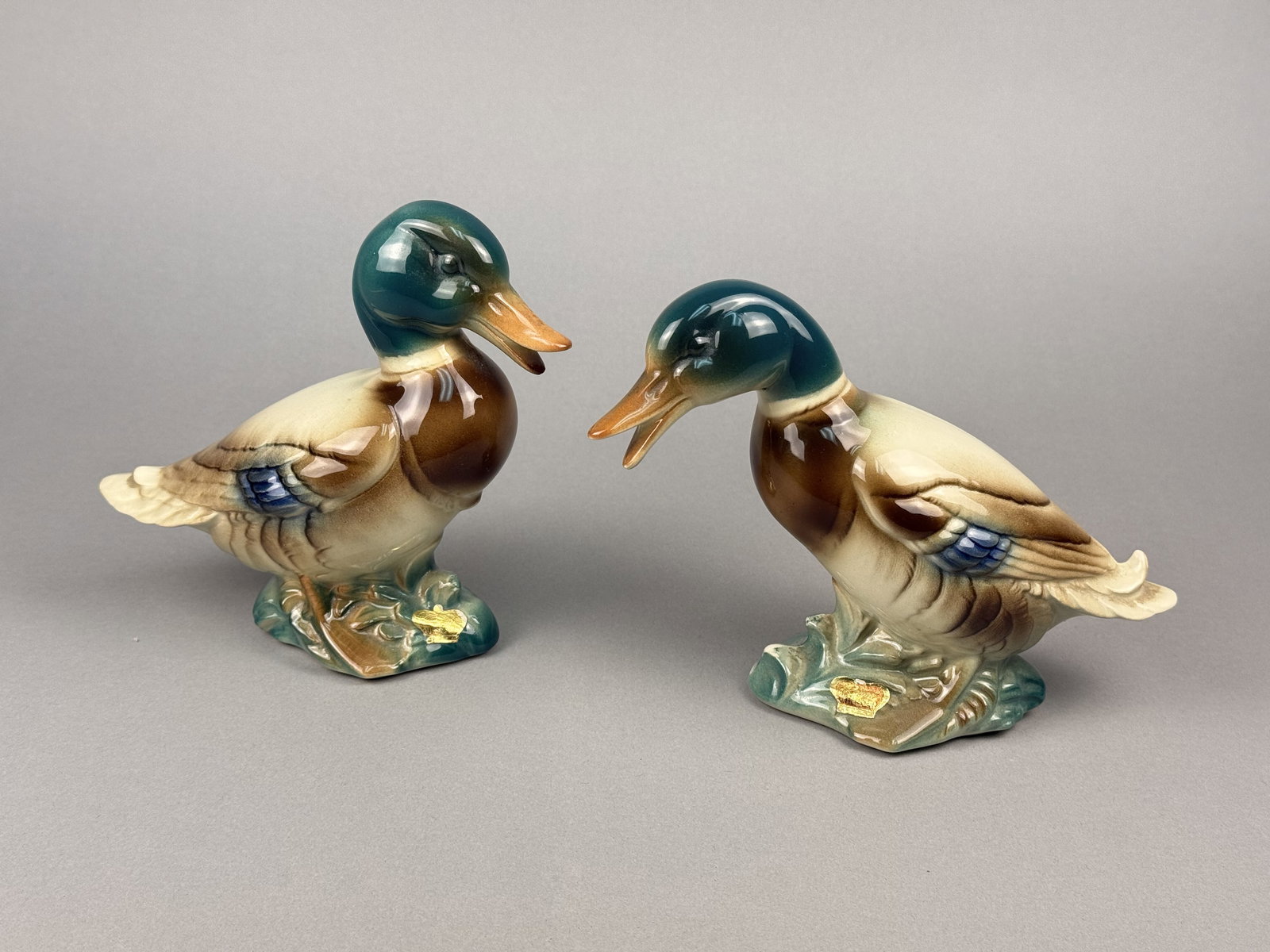 Pair of Mid-Century Glazed Ceramic Mallard Duck Figurines: Attributed to the Royal Copley line of the Spaulding China Company, these pieces are representative of American mid-century ceramic production. One figurine is modeled in a standing, upright