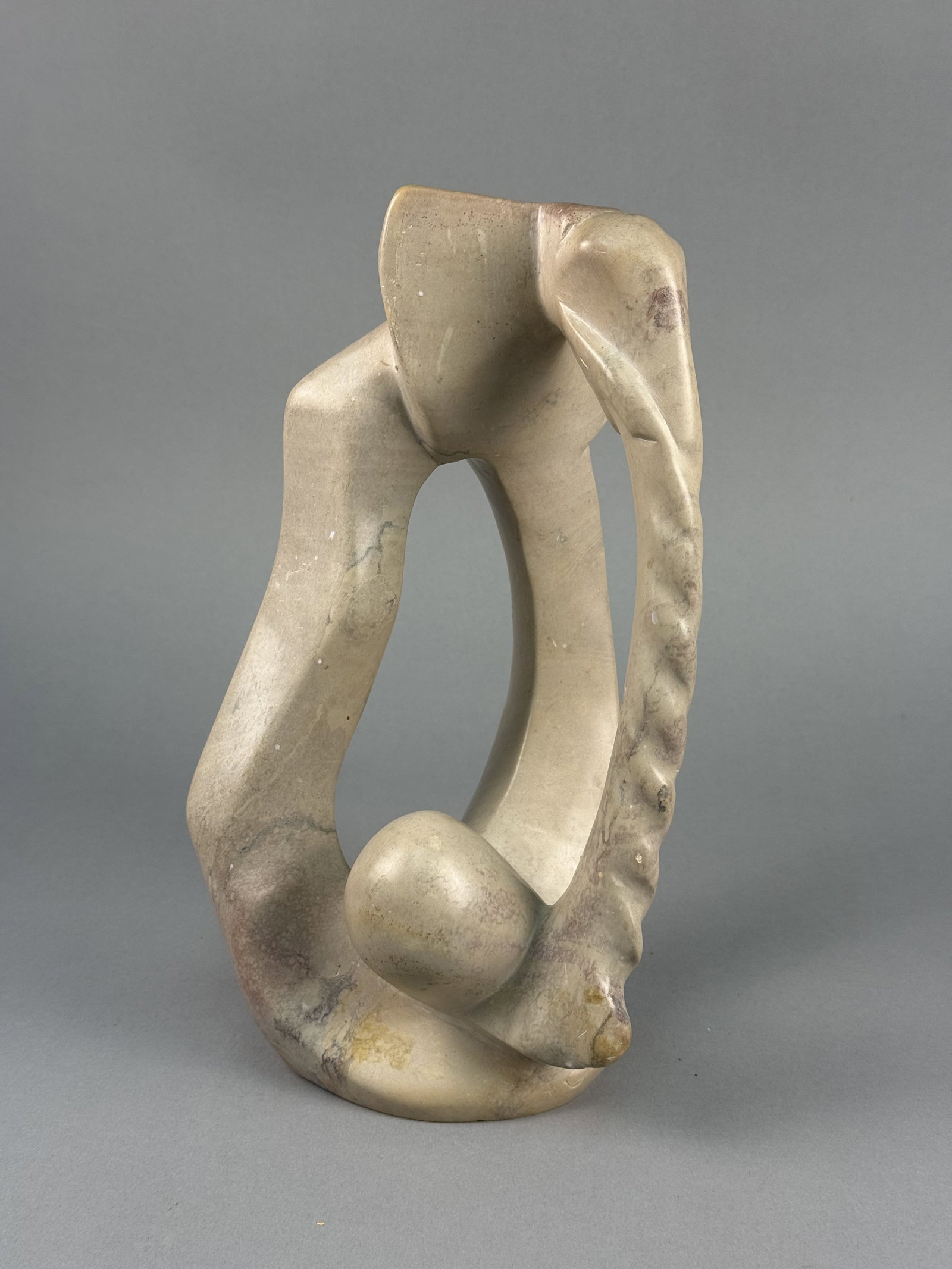 Originelle Kenyan Modernist Hand-Carved Soapstone Elephant Sculpture: Produced in Kenya and distributed by Originelle of Berkeley, California, the work is crafted from a single block of variegated soapstone featuring a natural palette of cream, gray, and reddish-tan hue