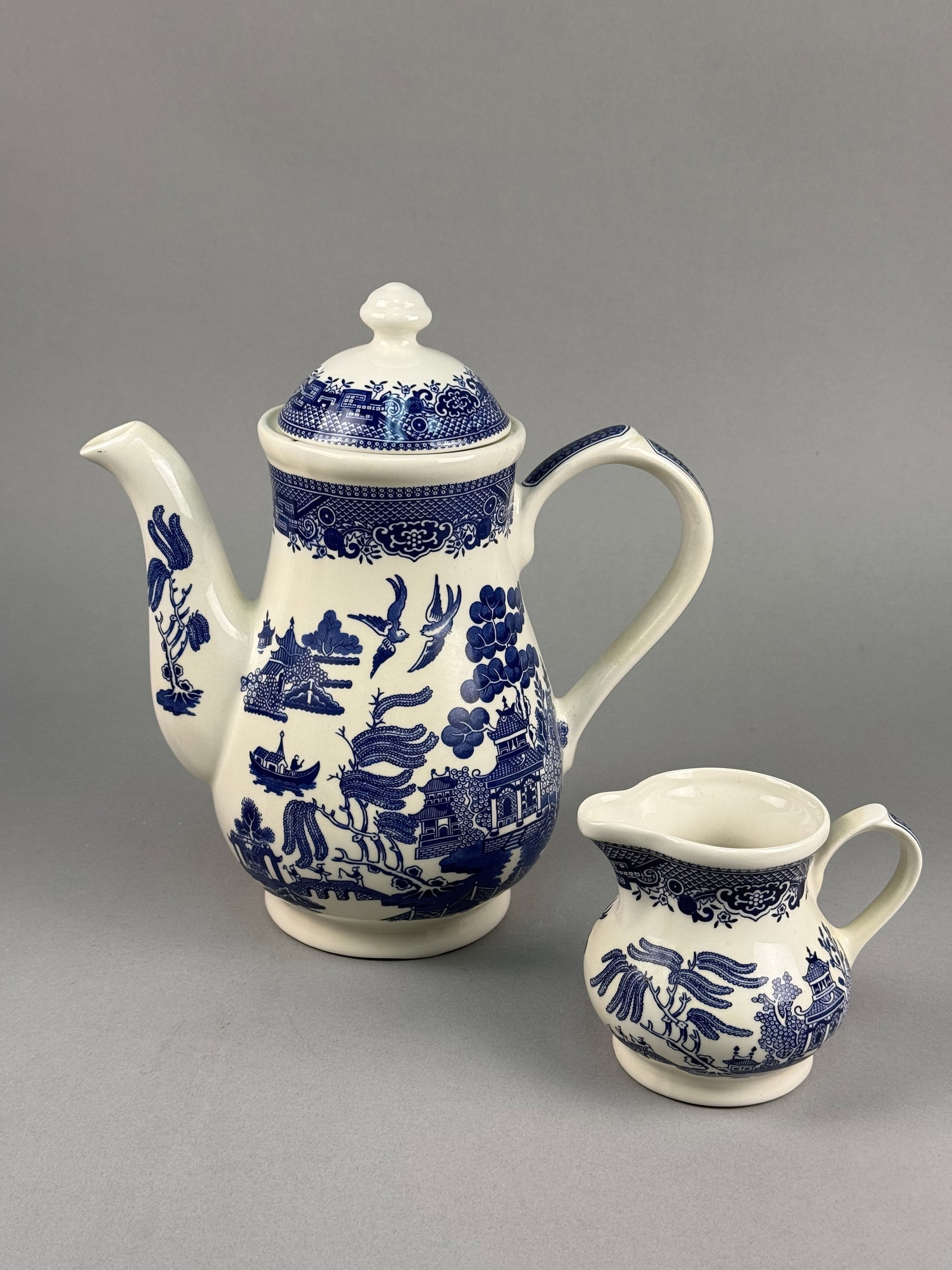 Churchill Blue Willow Ceramic Tableware Pieces: This set of Churchill ceramic tableware is decorated in the traditional Blue Willow pattern and was produced in Staffordshire, England. The group consists of a tall, lidded coffee pot and a matching