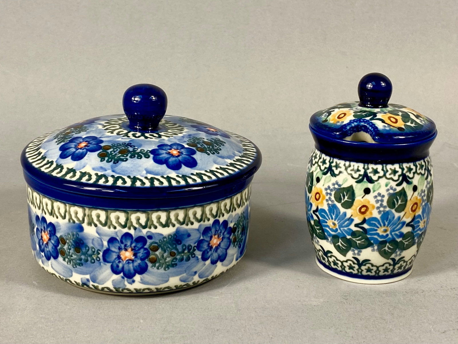 Two Polish Boles?‚awiec Ceramika Artystyczna Unikat Stoneware Covered Vessels: Two hand-painted stoneware vessels produced by the Ceramika Artystyczna cooperative in Boles?‚awiec, Poland. Both pieces feature Unikat artist-designed patterns on a cream ground. The first item is 